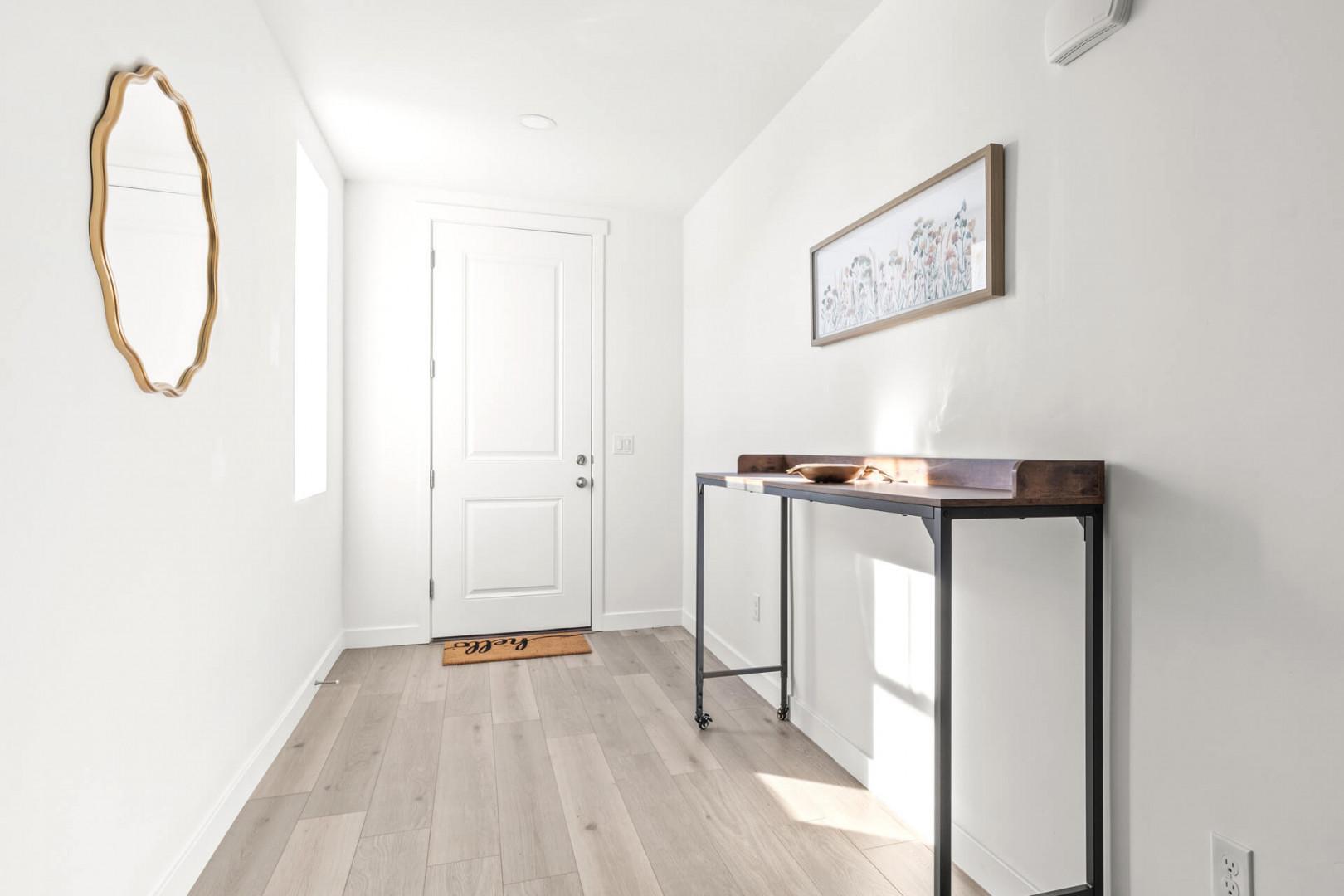Step inside to find a bright, welcoming entryway with light wood floors, modern touches, and thoughtful decor that sets a warm, relaxing tone for your stay.