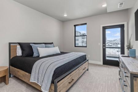 Mayflower Lakeside 104: Cozy bed by the window with a view of the outdoor patio.