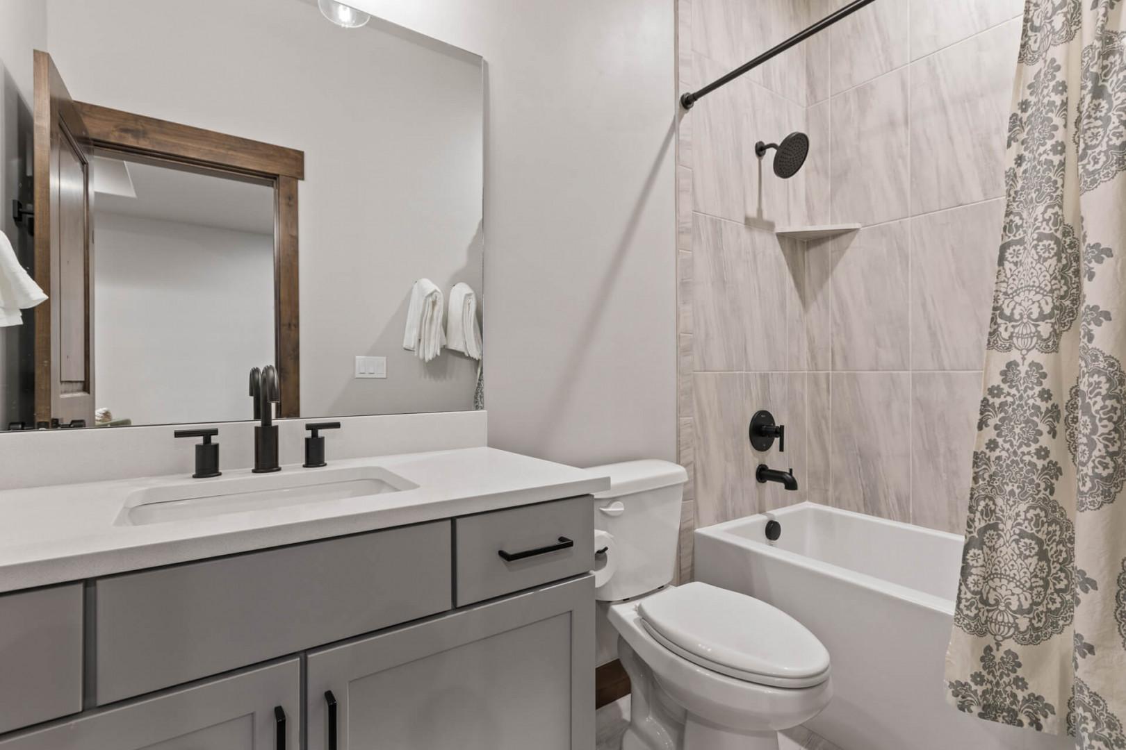 Black Rock Ridge 14536: Sleek sink, mirror, toilet, and convenient tub shower combo.