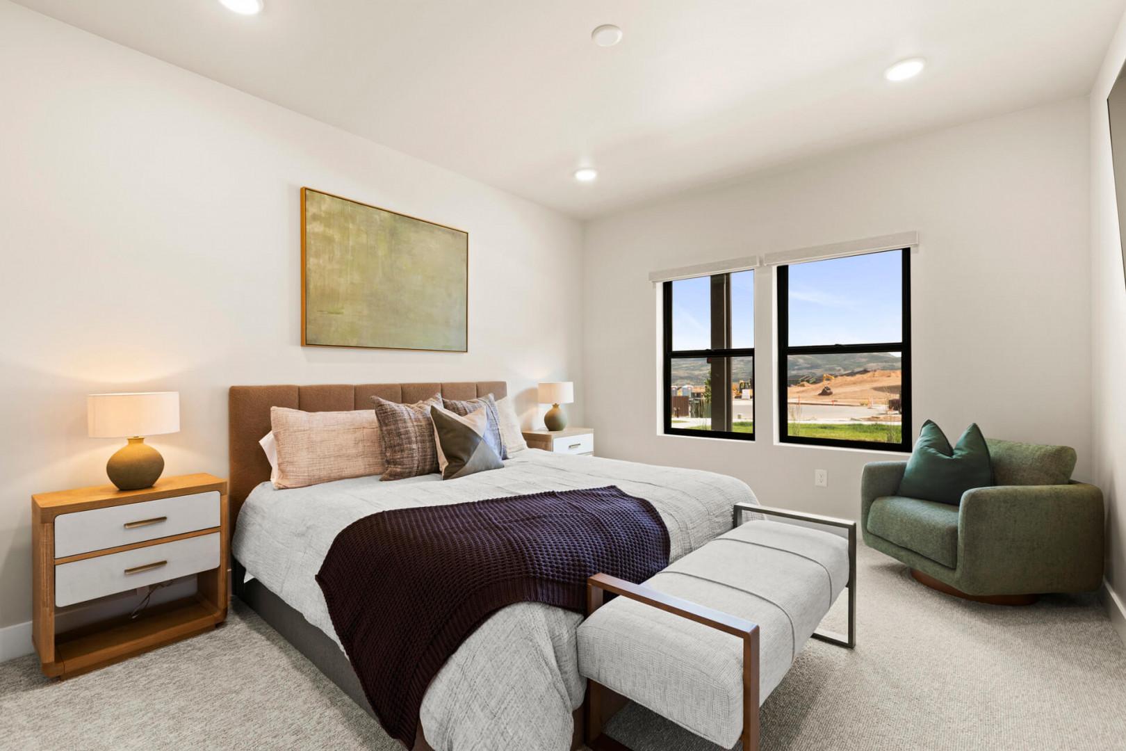 Drift off in your serene, sun-filled bedroom with plush bedding and peaceful countryside views framing the space. A cozy reading nook awaits, perfect for unwinding after exploring the area.