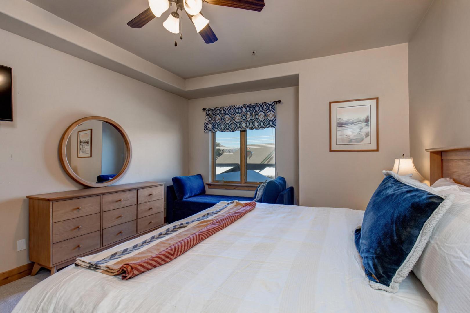 Sink into crisp white linens and plush pillows in your peaceful bedroom retreat, complete with cozy seating and mountain views.