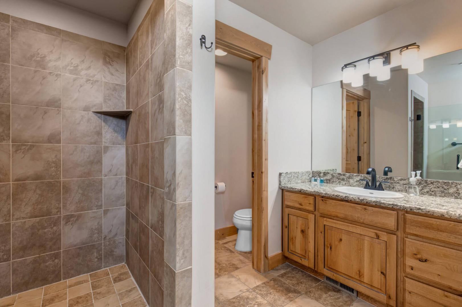 Relax in your spacious master bath with elegant stone shower, granite counters, and rustic wood vanity.