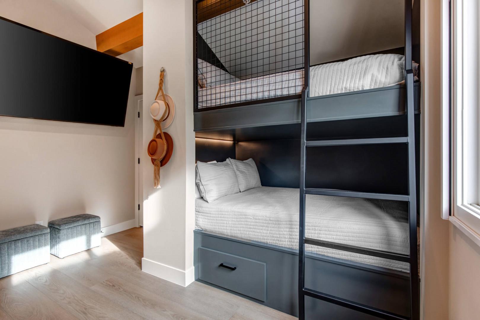 Upper Main 301: Your custom bunk beds feature crisp linens and smart storage, perfect for traveling companions in this thoughtfully designed space.