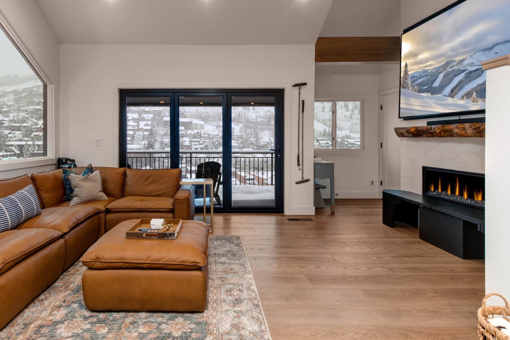 Upper Main 301: Cozy up in this stylish living room with leather seating, fireplace warmth, and stunning mountain views from your private balcony.