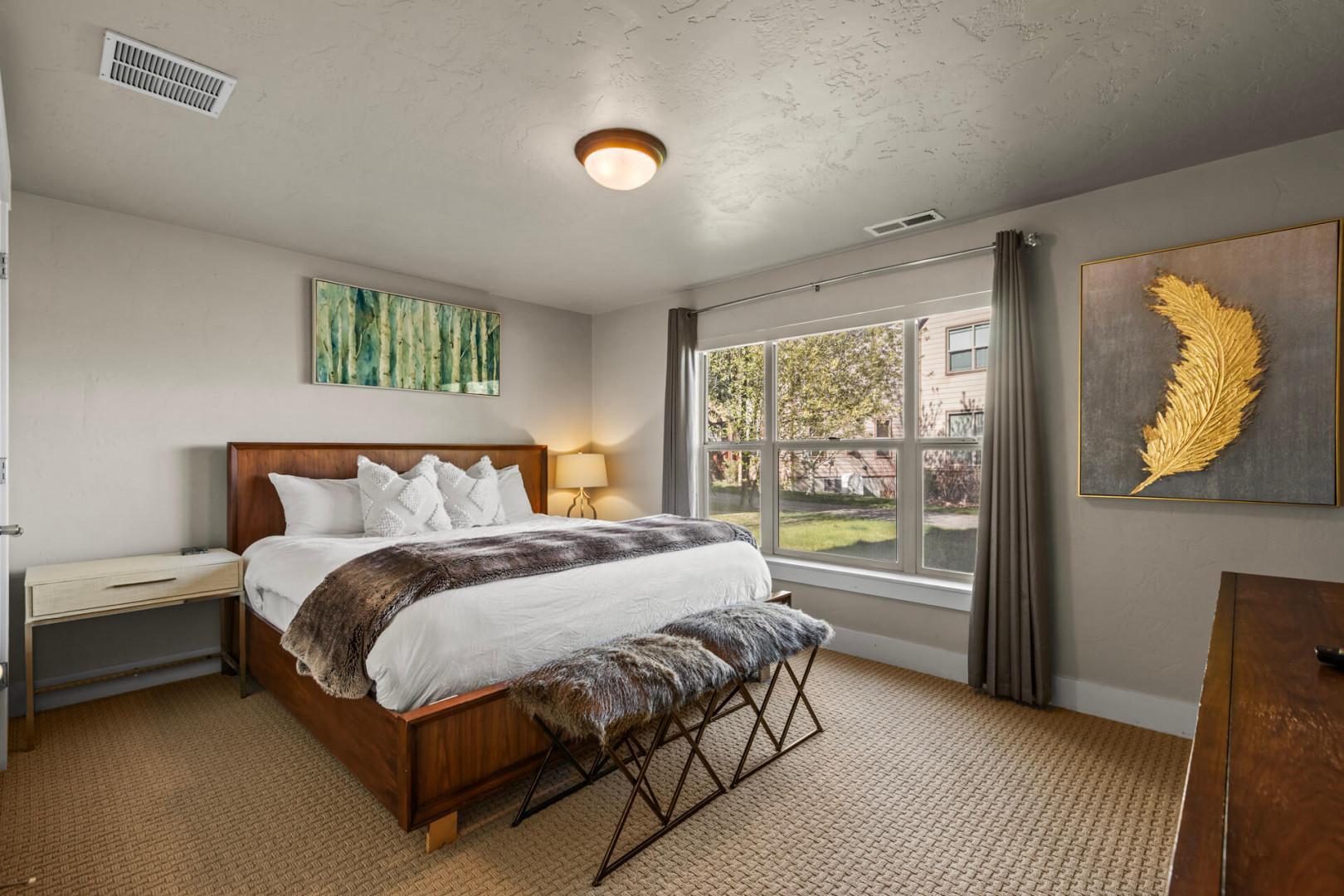 Sink into your plush king bed with crisp linens and textured throws, enjoying natural light streaming through your private windows.