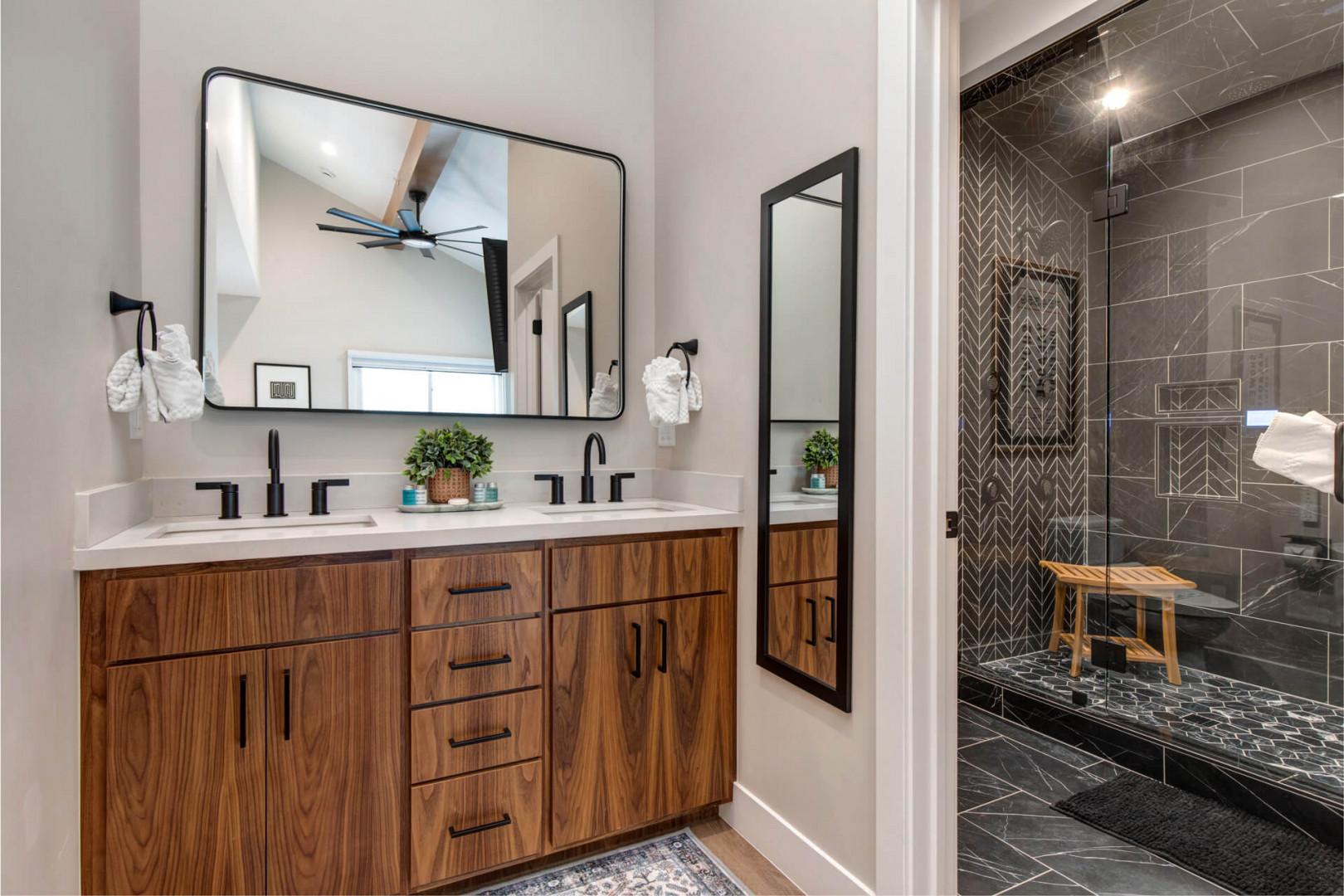 Upper Main 301: Unwind in your spa-like bathroom featuring a stunning walk-in shower with designer tile work and warm wood vanity.