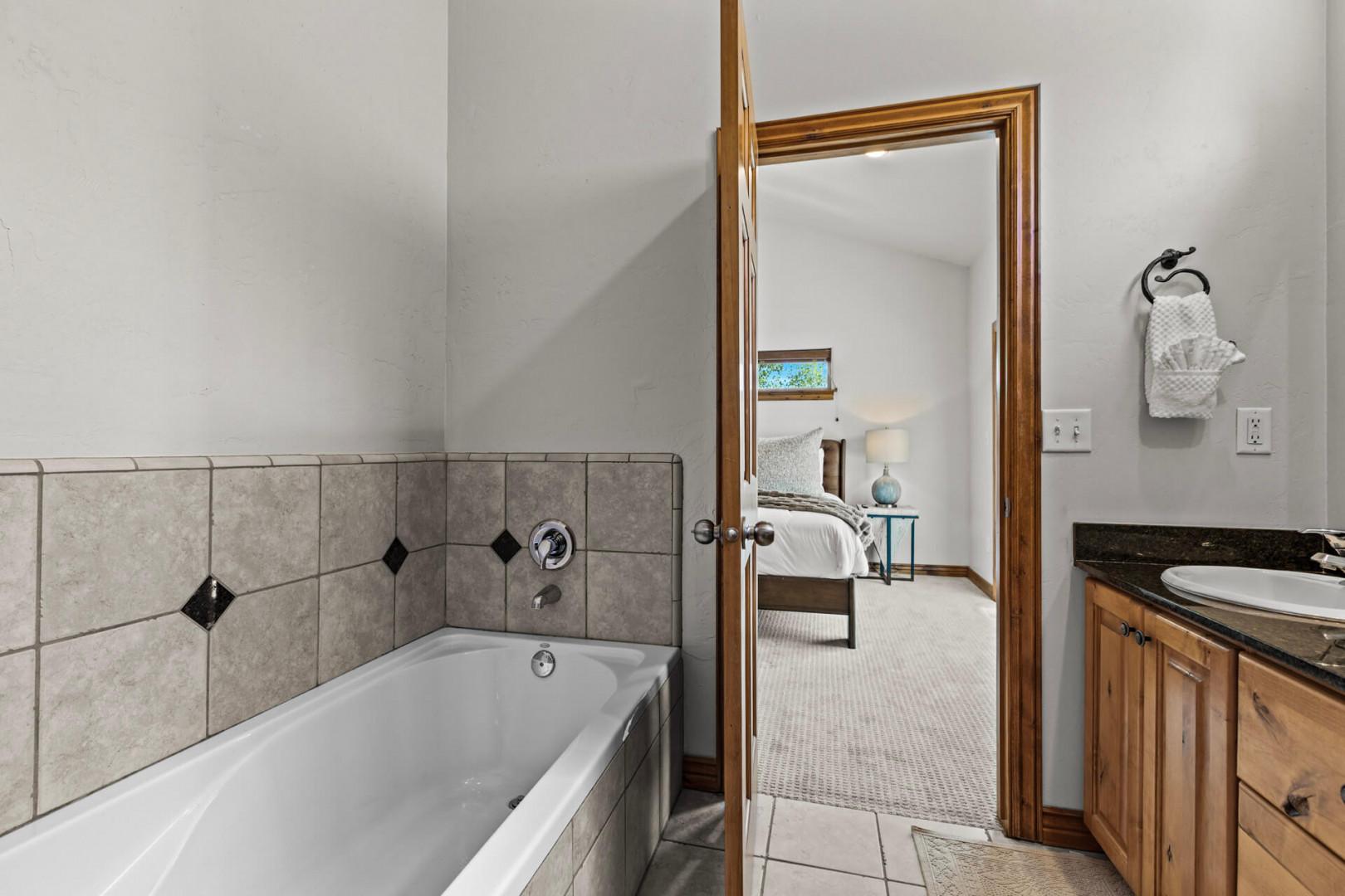 Your private en-suite bathroom features a soaking tub and direct access to a serene bedroom retreat—perfect for unwinding after a day of adventure.