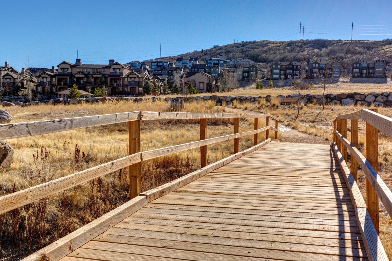 Wooden boardwalk winds through the natural landscape near the property, offering a peaceful connection to the surrounding area and hillside neighborhood beyond.