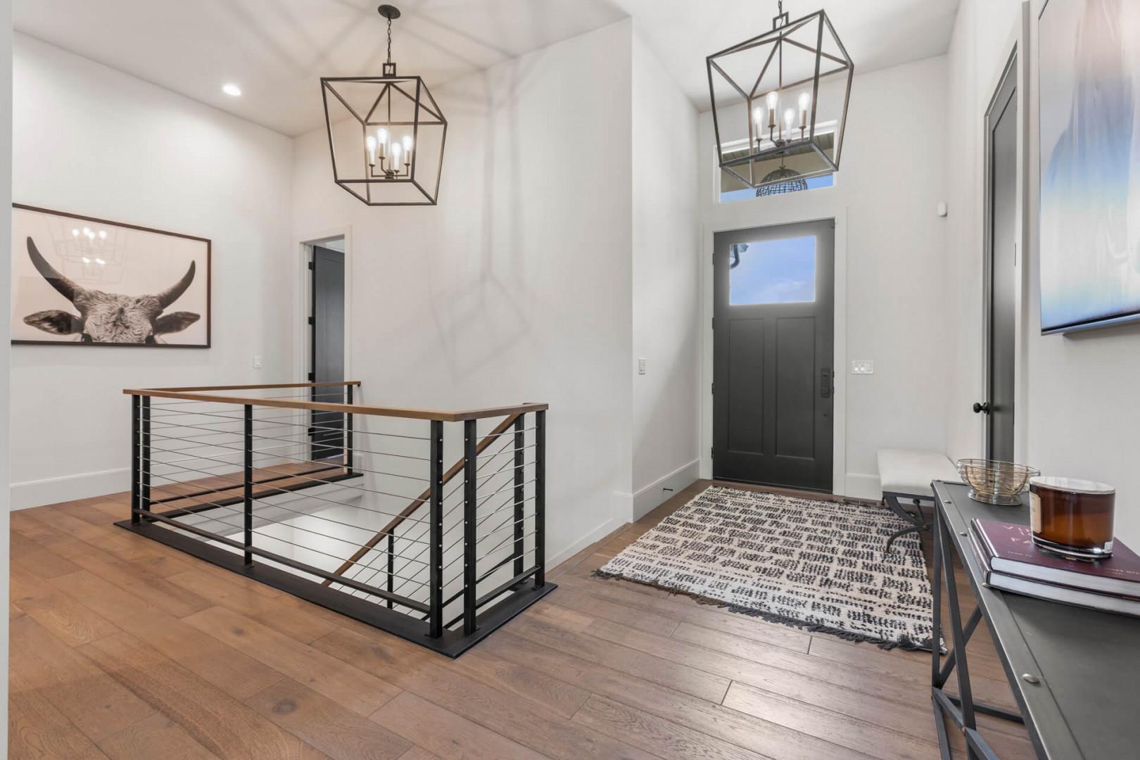 Step into your spacious entryway where soaring ceilings, modern finishes, and stylish lantern lighting welcome you home to a bright, open sanctuary.