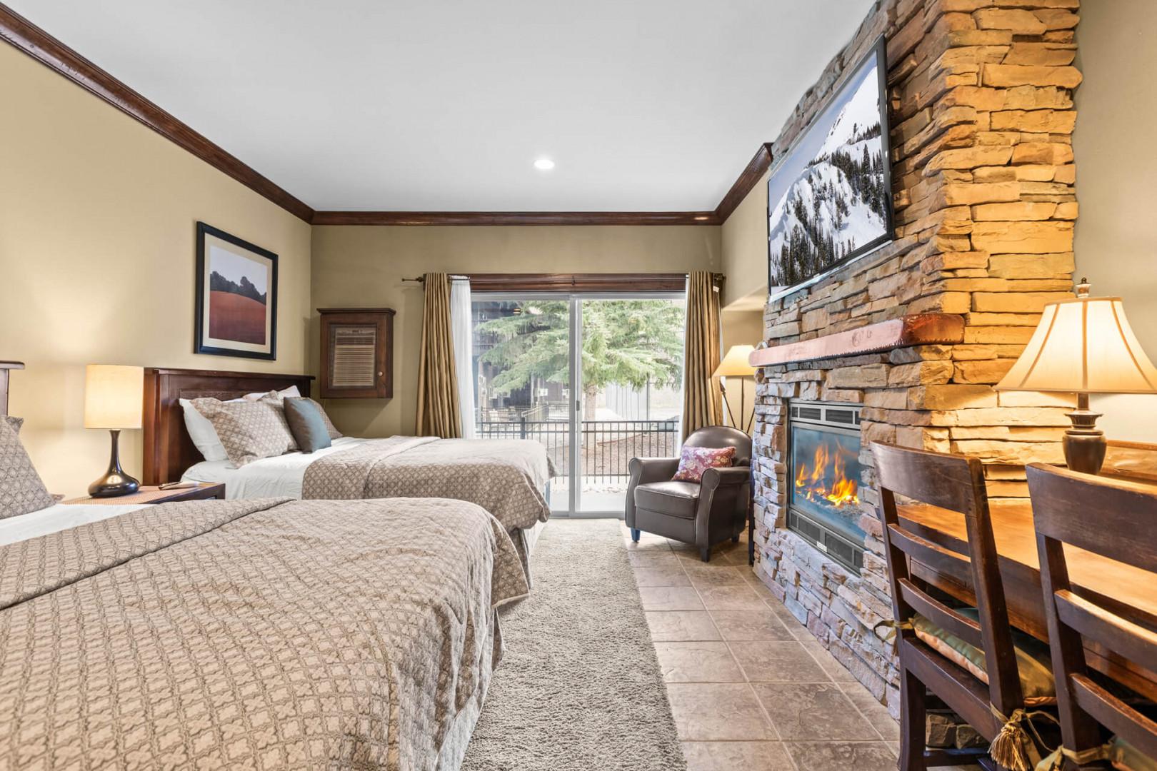 Sink into plush beds after a day of adventure, and warm your toes by the crackling stone fireplace. Natural light streams through glass doors leading to your private balcony, where mountain views await.