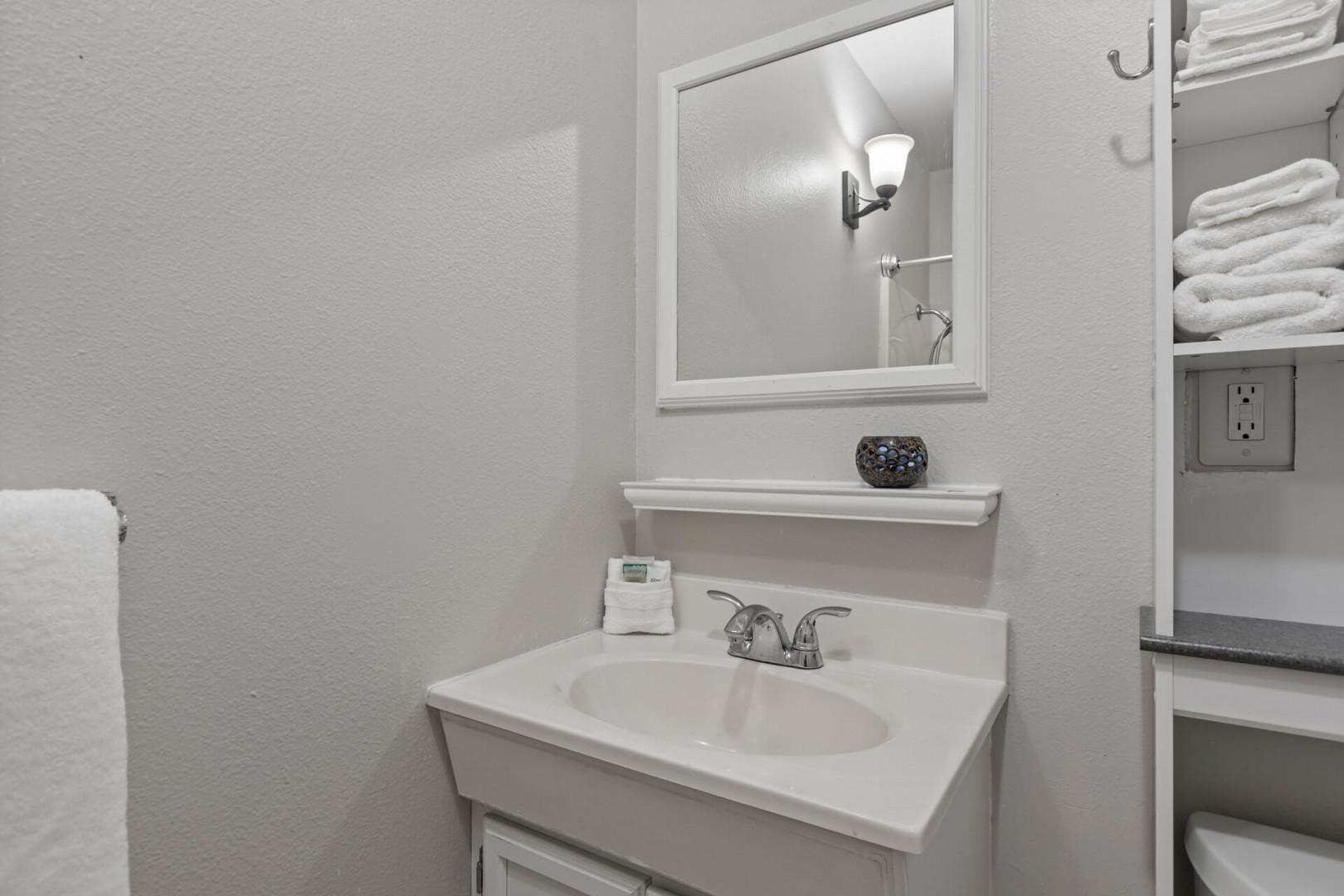 Reflective sink area with a sleek mirror, perfect for morning routines.