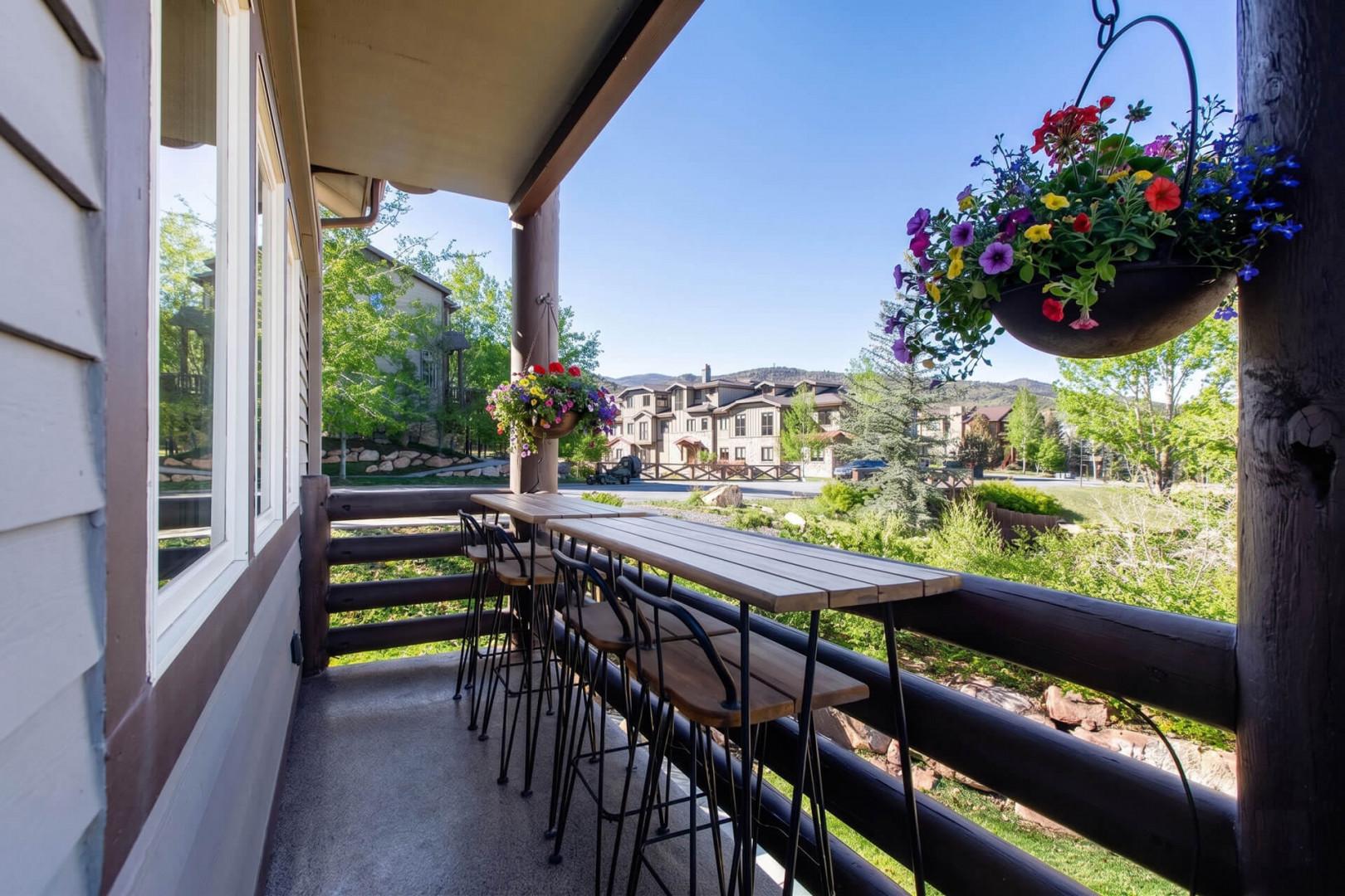 Enjoy morning coffee on this charming covered balcony overlooking a peaceful residential neighborhood. Hanging flower baskets add a welcoming touch to your private outdoor retreat.