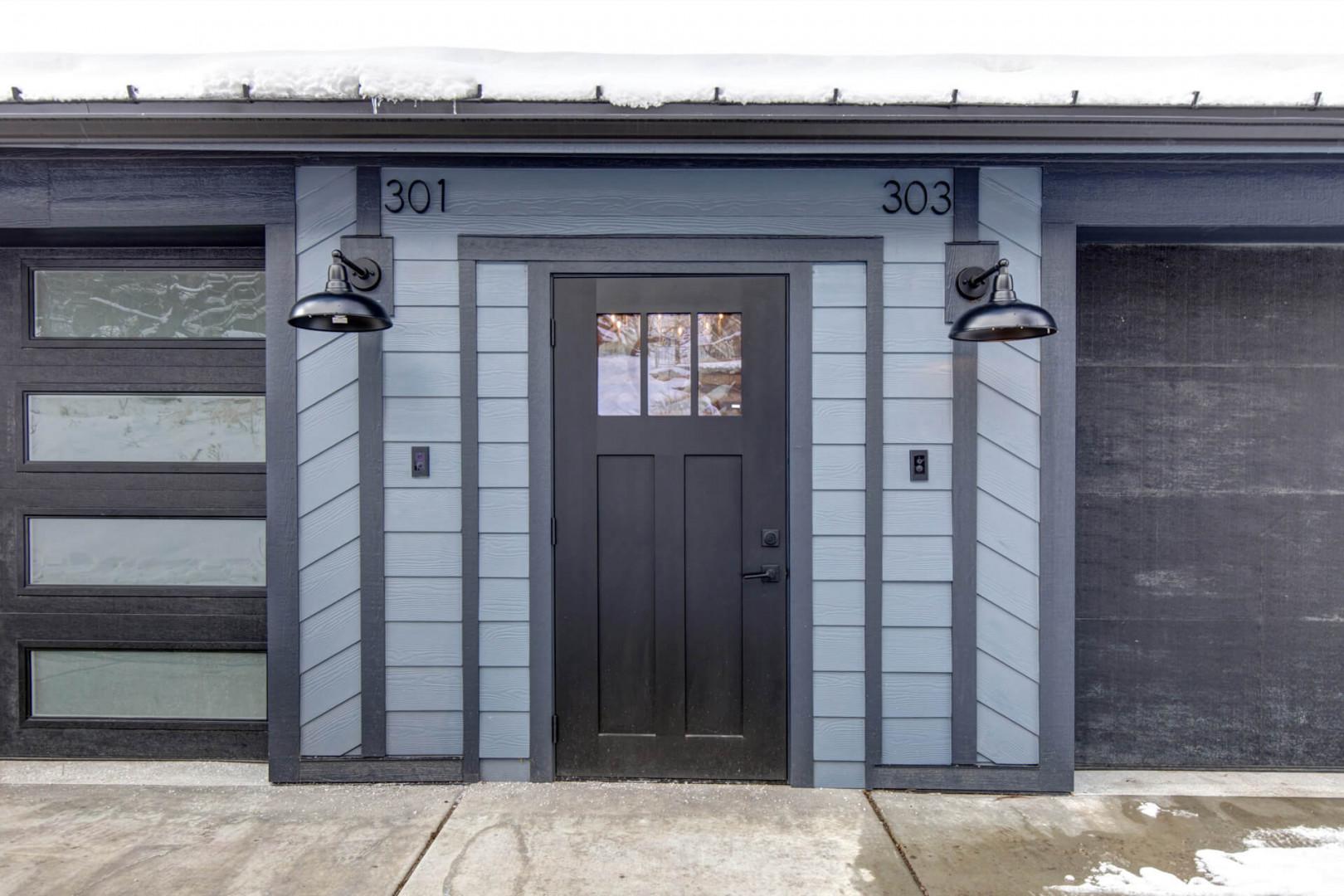 Modern entrance featuring units 301 and 303 with contemporary design and industrial-style lighting fixtures.