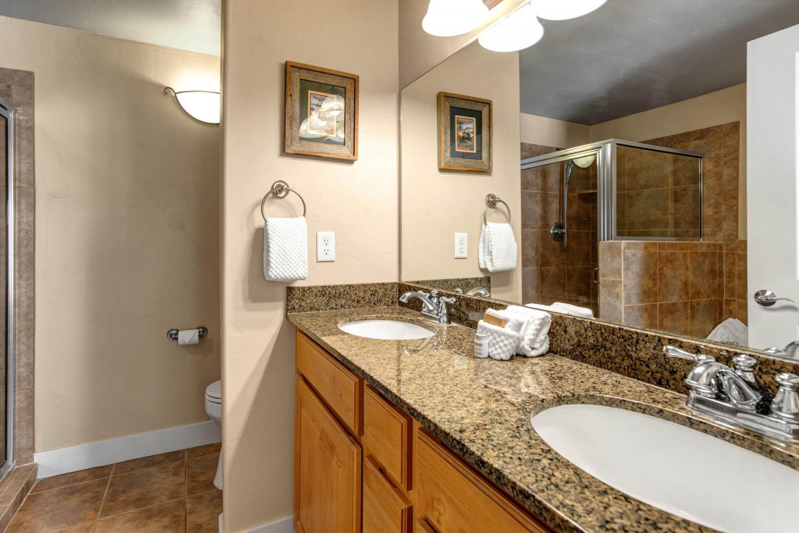 Your private bathroom features dual sinks with granite counters, warm lighting, and a spacious tiled shower—perfect for refreshing mornings or unwinding after your adventures.
