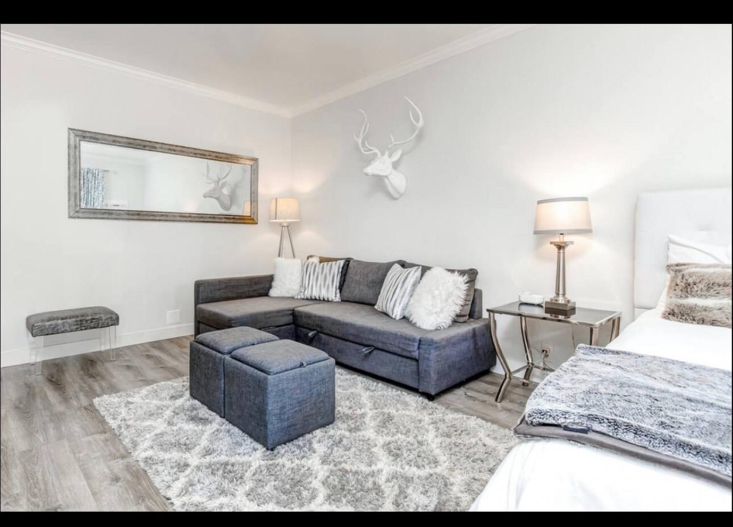 Relax in your stylish sanctuary with plush seating, soft throws, and elegant deer antler decor creating the perfect cozy atmosphere.