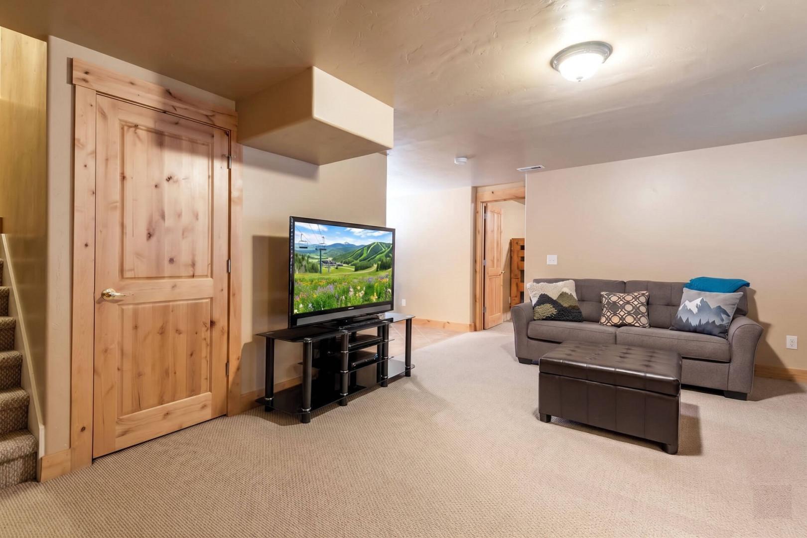 Relax in your spacious lower-level living area with a comfy sofa, large flatscreen TV, and warm wood accents. Perfect for unwinding after a day of exploring the mountains.