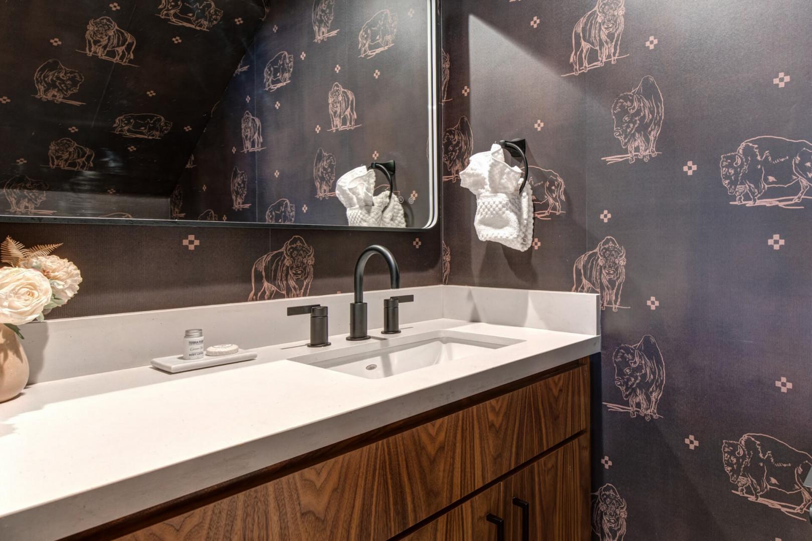 Main Level Half Bathroom: Freshen up in your stylish bathroom featuring whimsical wallpaper, modern fixtures, and thoughtful touches that make every moment feel special.