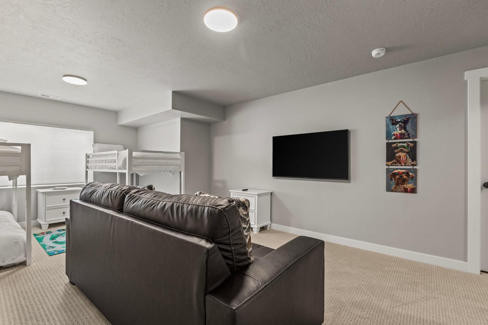 Unwind in your cozy living area with comfortable seating, wall-mounted TV, and bunk beds perfect for family gatherings.