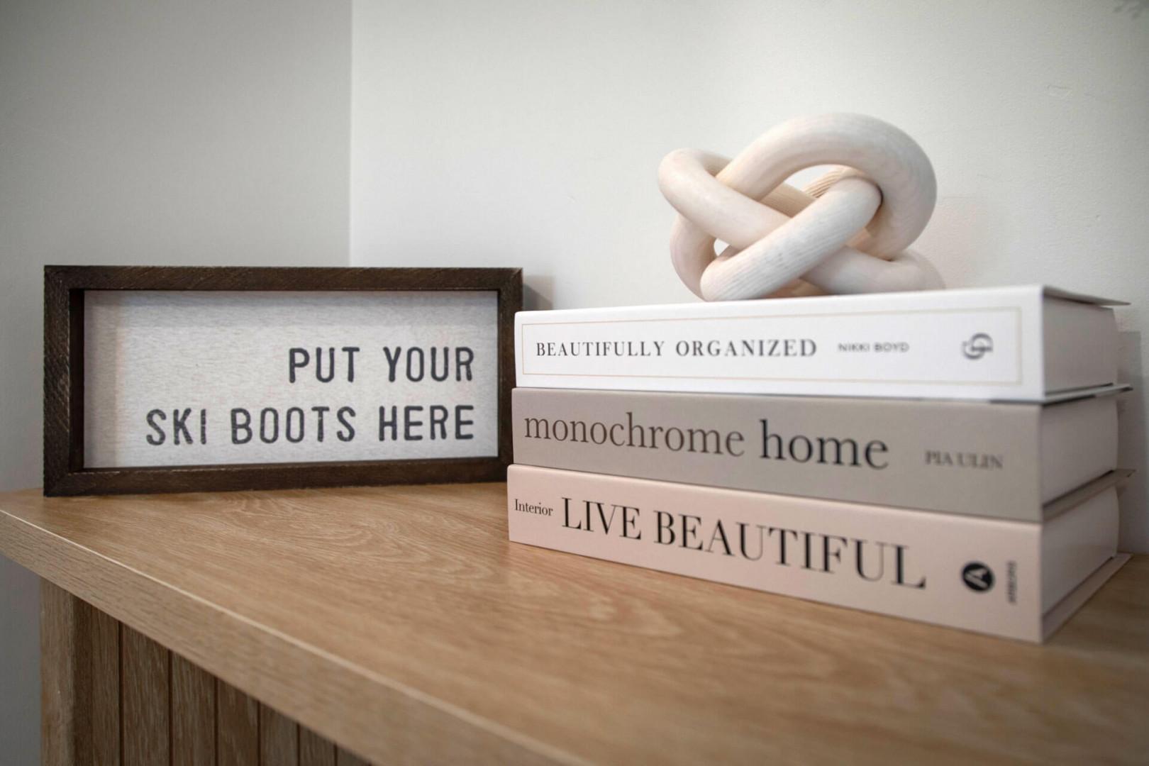 Thoughtful decor touches make your space feel like home, with ski-themed humor and stylish books creating a cozy atmosphere.