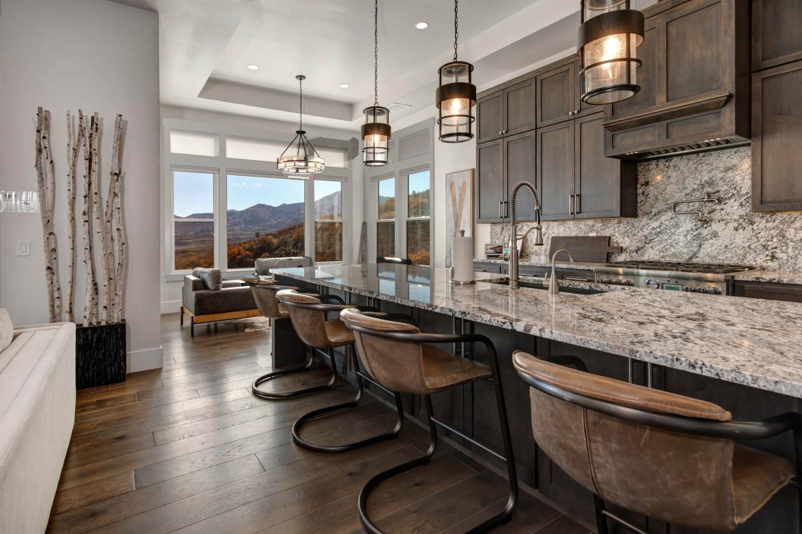 Deer Springs 12797: In the center of the  kitchen is a spacious island with casual barstool seating that’s illuminated by unique, modern pendant lights.