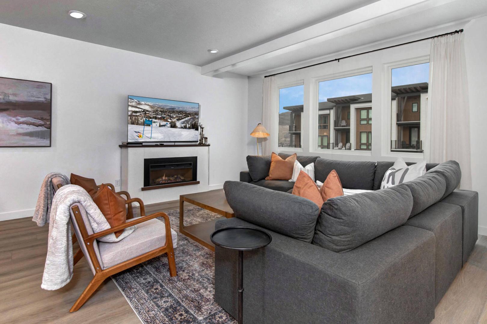 Sink into your cozy sectional by the fireplace, where modern comfort meets mountain charm in your stylish living room.