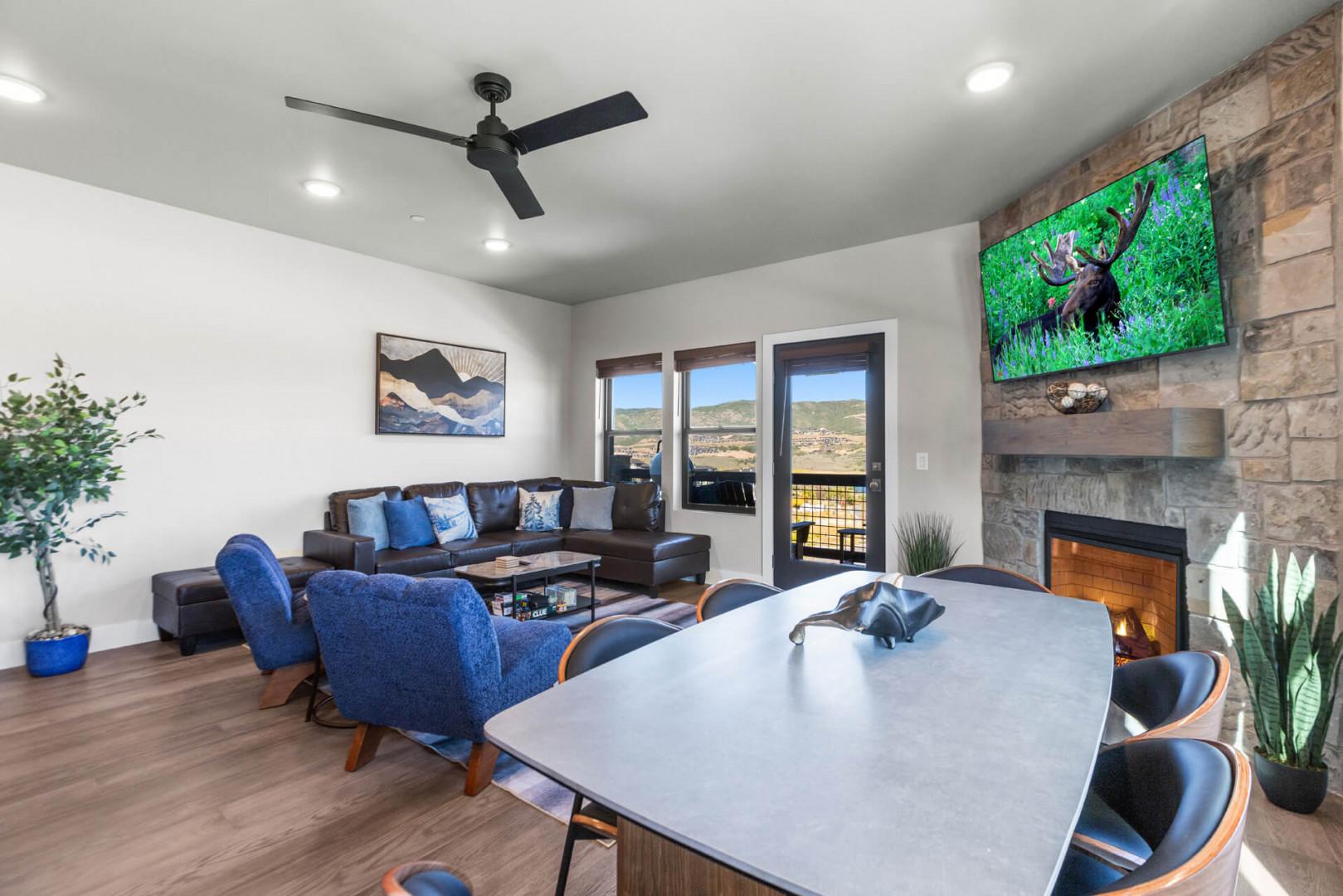 Gather in this inviting living space where modern comfort meets mountain style. Sink into plush seating by the stone fireplace, enjoy your favorite shows, and take in the desert landscape through floor-to-ceiling windows.