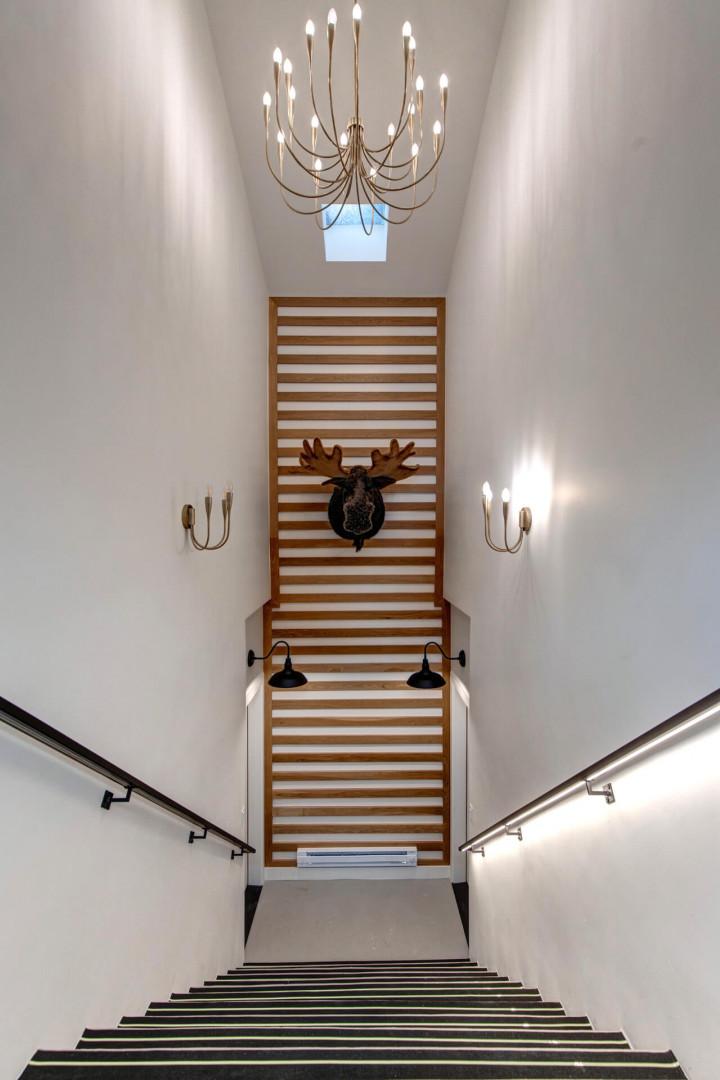 Upper Main 301: Ascend this stunning staircase where modern elegance meets rustic charm, with dramatic lighting and unique décor creating an unforgettable entrance.