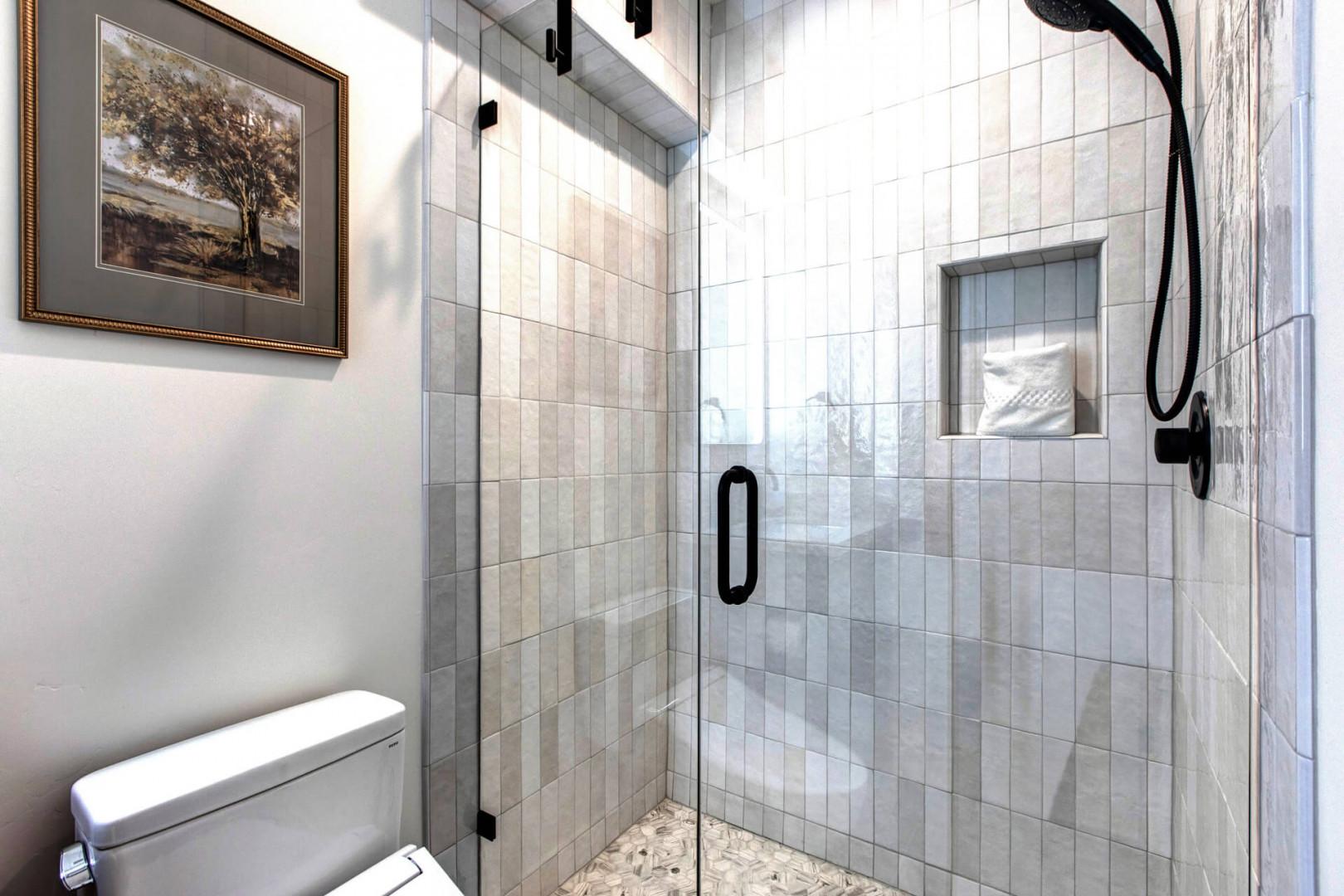 Step into your private spa-like retreat with elegant marble tiles, rainfall shower, and built-in niche for your essentials.