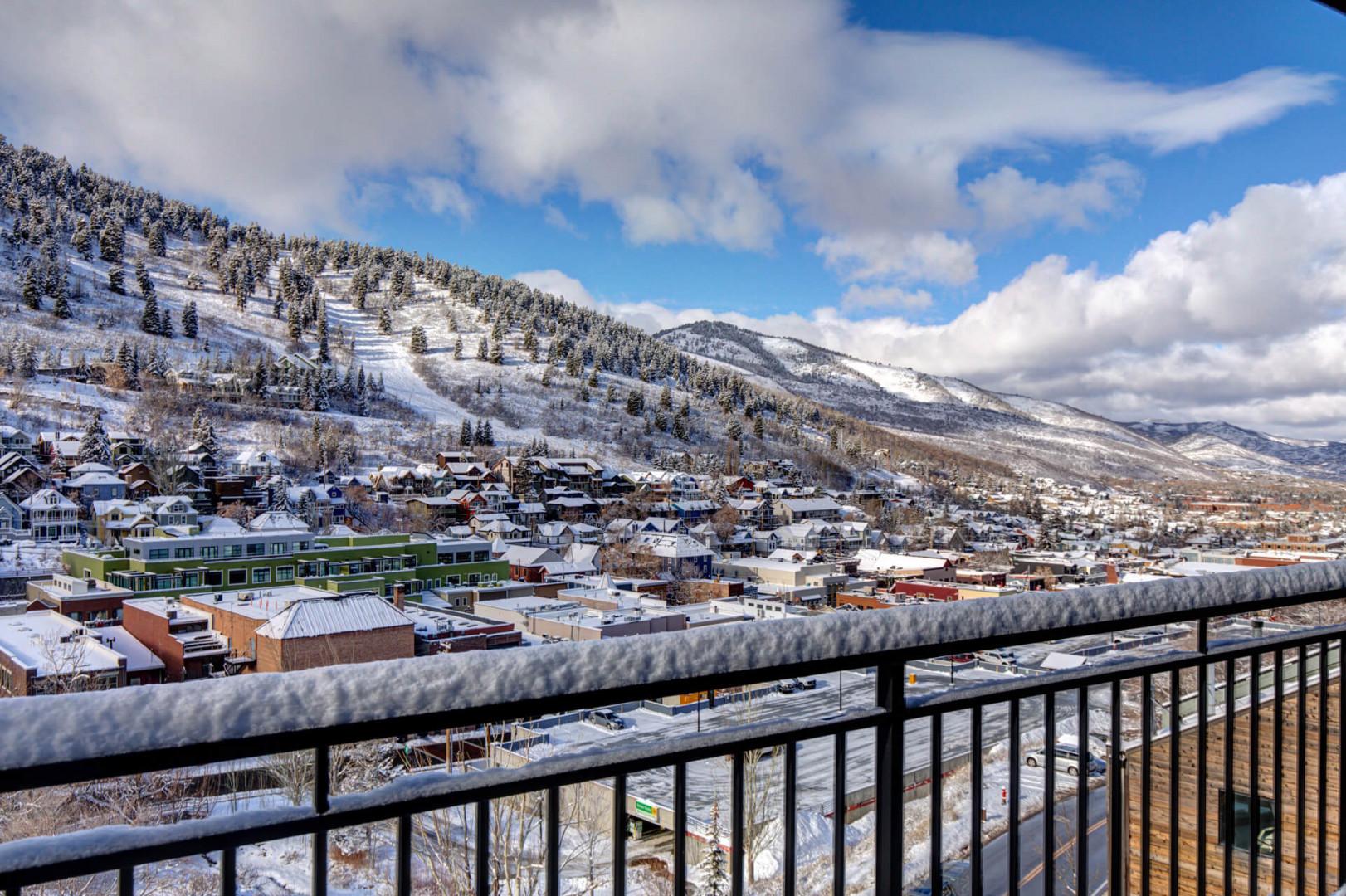 Upper Main 301: Stunning mountain town vista with snow-covered peaks and charming alpine village below from private balcony.