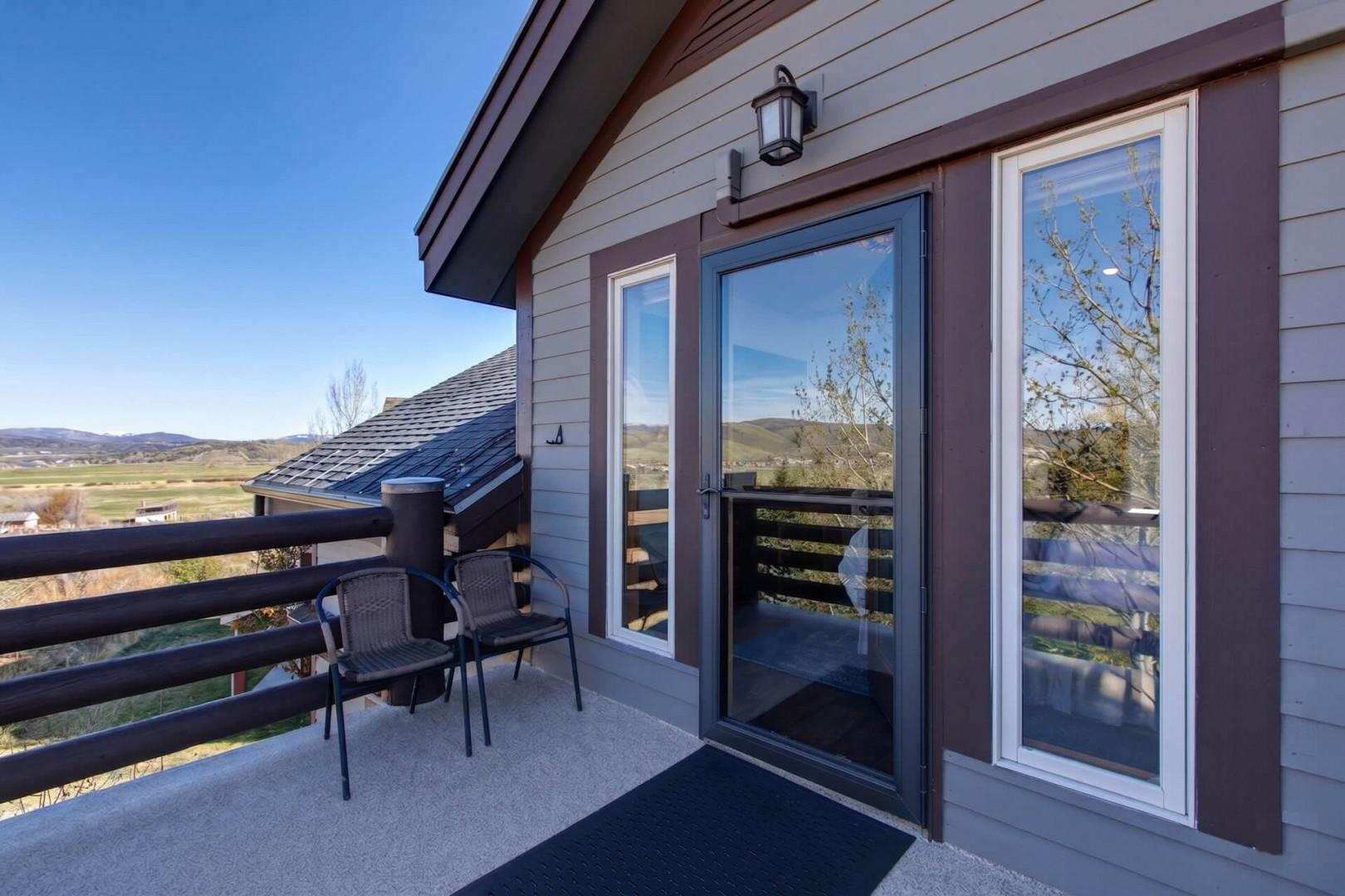 A charming private balcony offers sweeping views of rolling hills and valleys, perfect for your morning coffee or evening wind-down with comfortable seating and peaceful scenery.