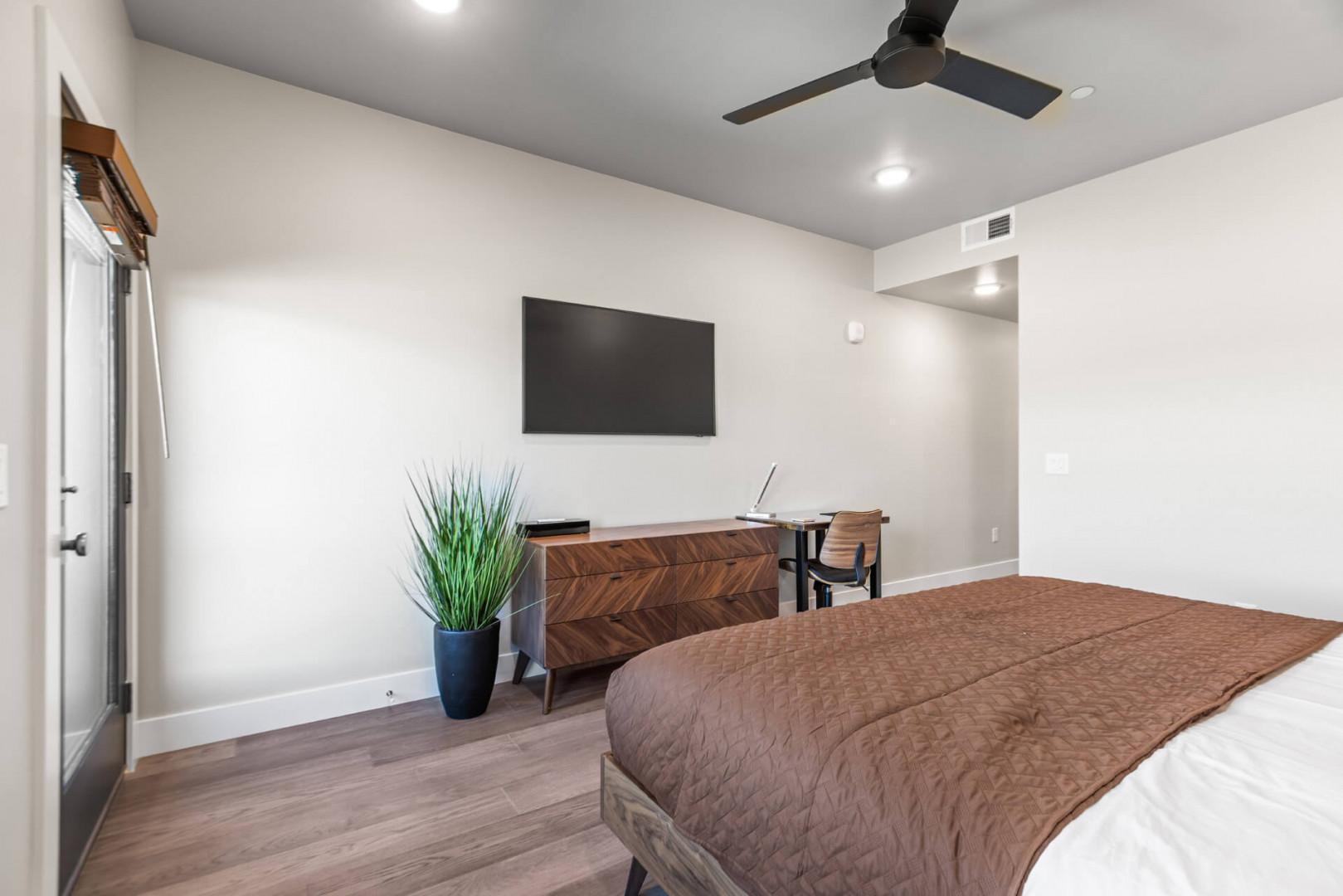 Unwind in your serene retreat with a plush bed, modern workspace, and calming décor—perfect for rest or catching up on work.
