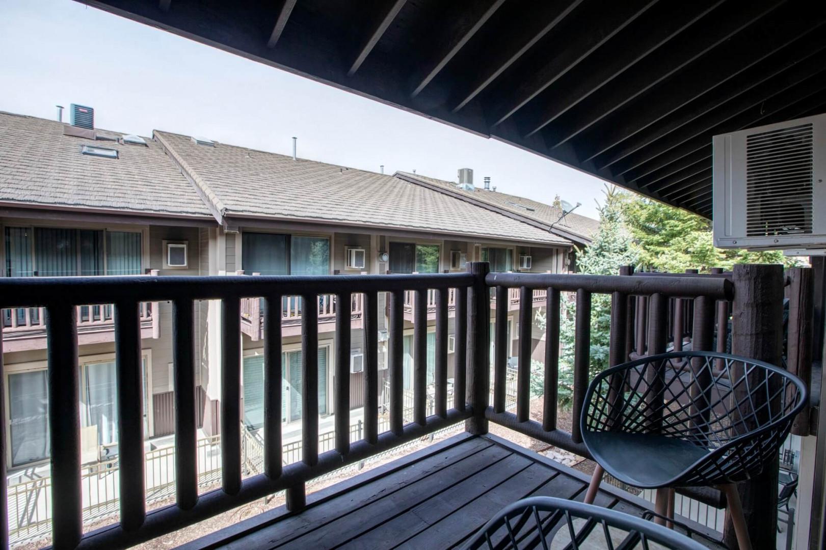 Step onto your private balcony with modern seating where you can enjoy peaceful views of the surrounding courtyard and buildings.