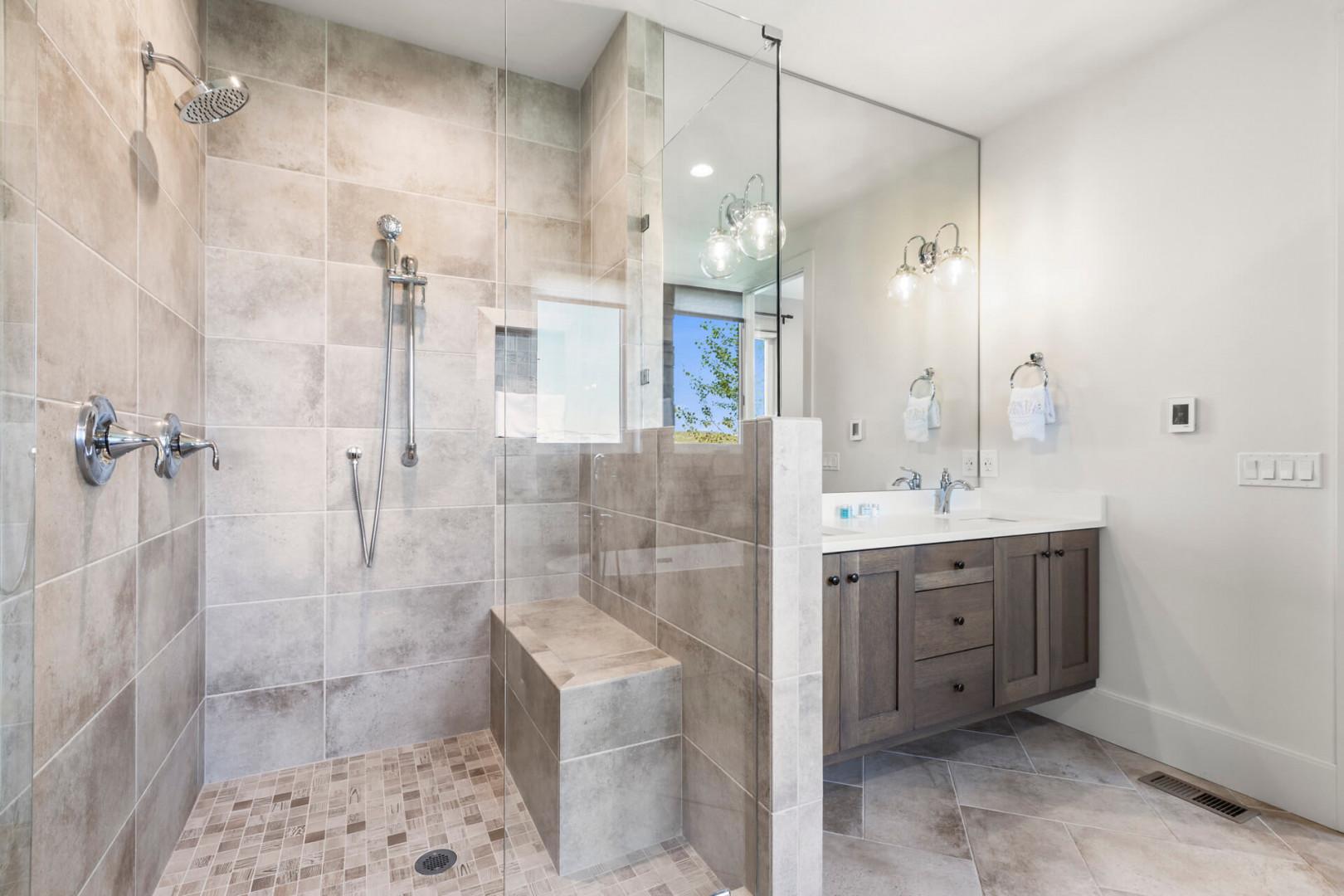 Refresh in your spa-like bathroom with a spacious walk-in shower, dual rainfall showerheads, and built-in bench. Clean lines, elegant fixtures, and natural light create a modern sanctuary for your daily routine.
