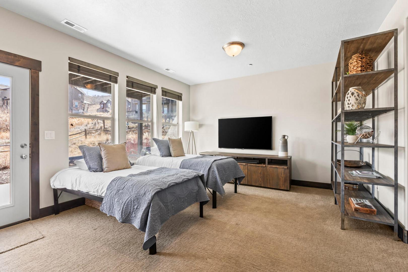 Sink into plush twin beds with soft gray linens while enjoying your entertainment center and mountain views through oversized windows.