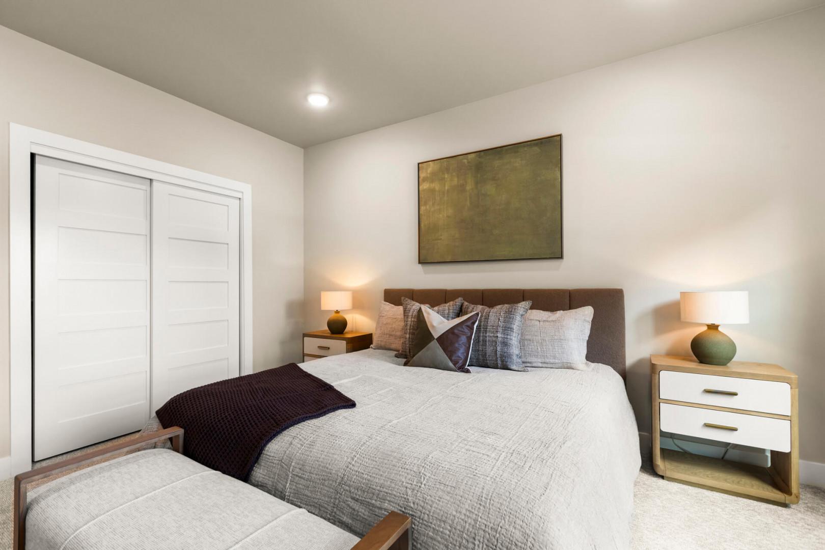 Sink into crisp linens and plush pillows in your peaceful bedroom retreat, where warm lighting and modern design create the perfect space to unwind after a day of adventure.