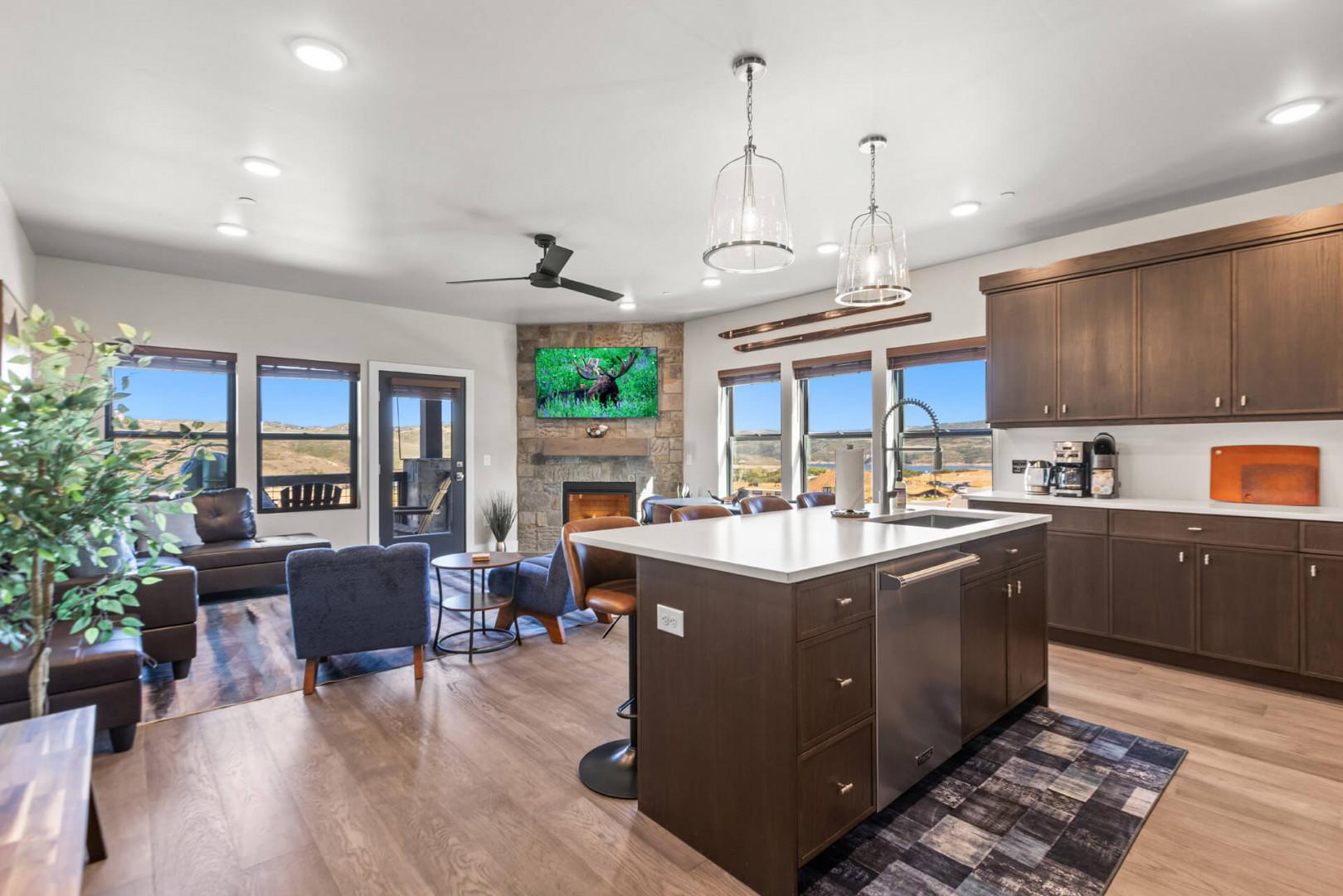 Gather in your open-concept living space where the kitchen island invites conversation and the living area flows seamlessly into panoramic views of the surrounding landscape, creating the perfect backdrop for your getaway.