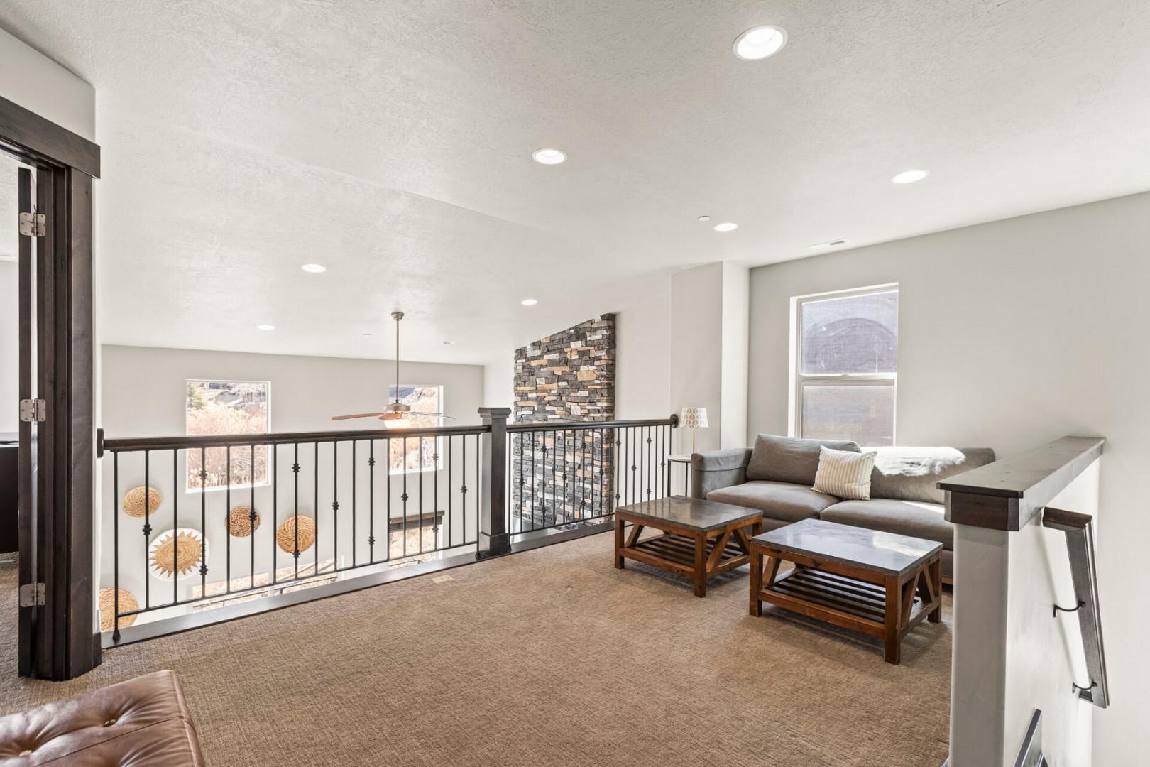 Unwind in your spacious upstairs loft with cozy seating, natural light, and mountain views through oversized windows.