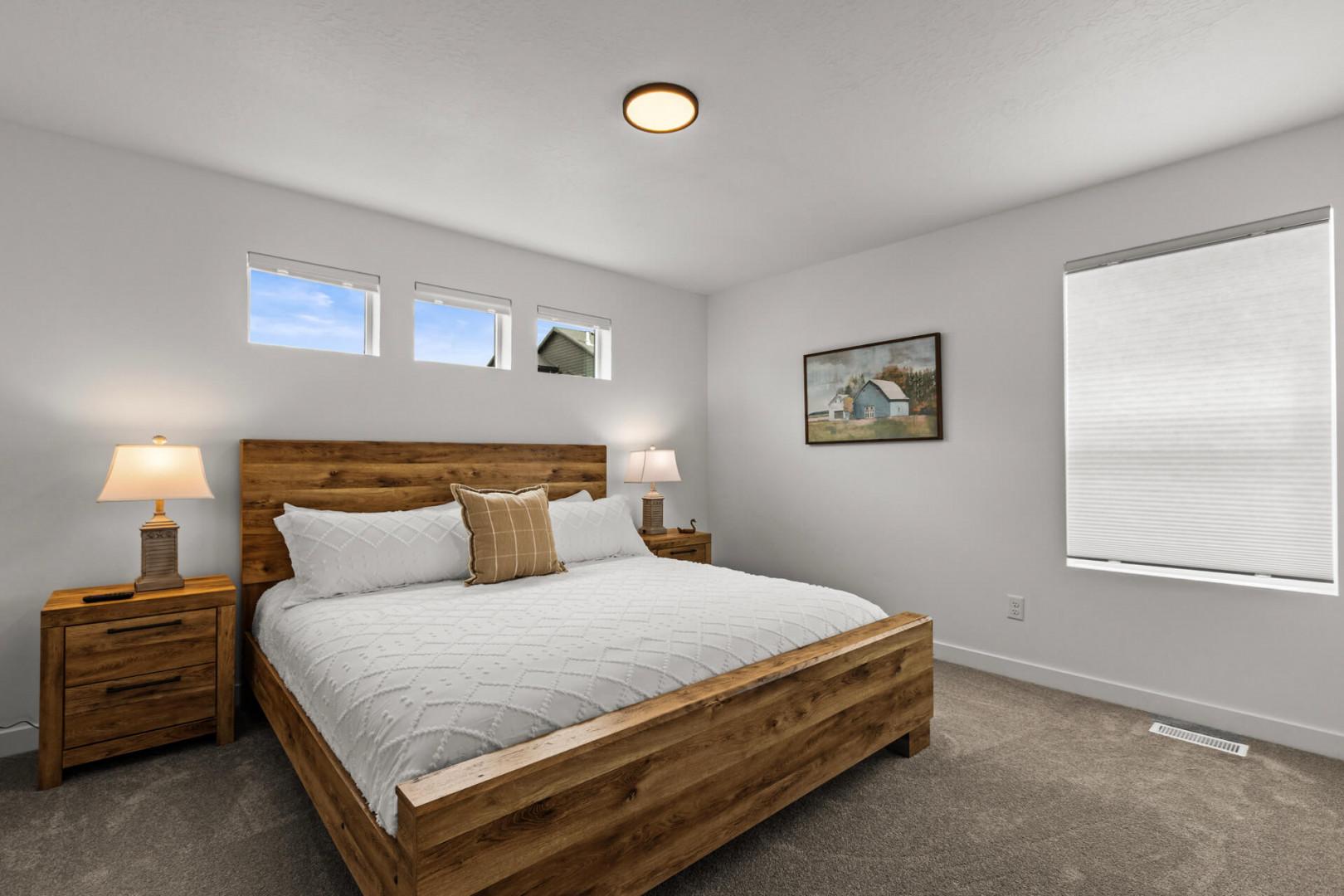 Sink into crisp white linens and rustic wood warmth in your peaceful bedroom retreat with natural light streaming through.