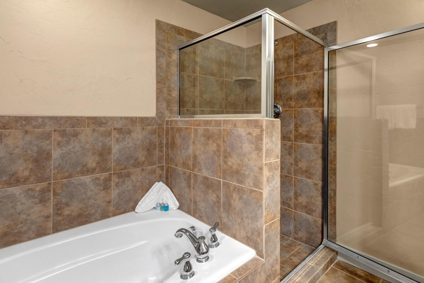 Unwind in your private spa-like bathroom with a luxurious soaking tub and separate walk-in shower, all beautifully appointed with warm tile finishes.