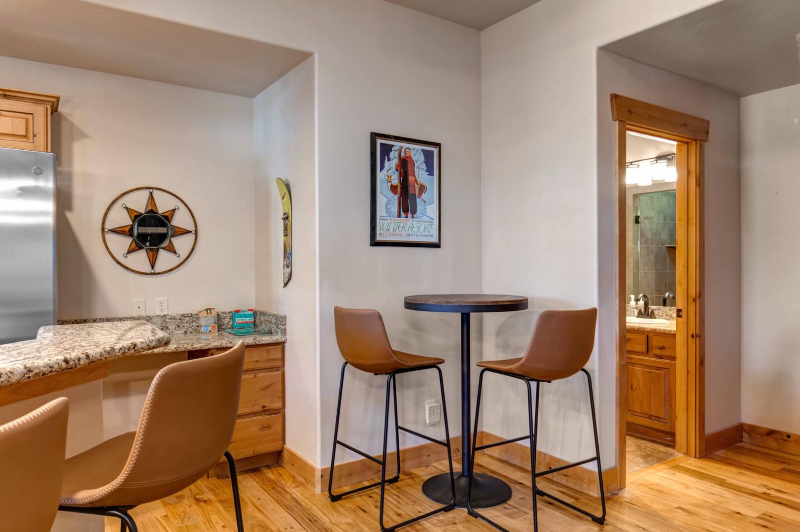 Your morning coffee tastes better at this stylish bistro table, where warm wood floors and vintage ski art create the perfect breakfast nook.