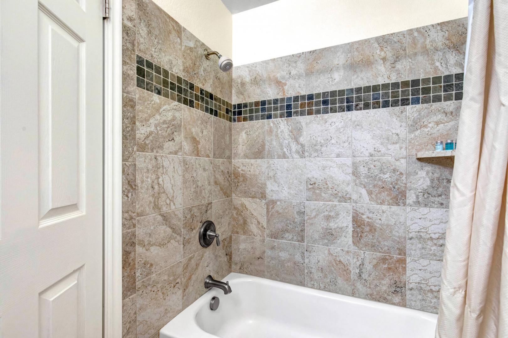 Enjoy your private tub and shower combination with beautiful mosaic tile accents and a skylight overhead for natural light.