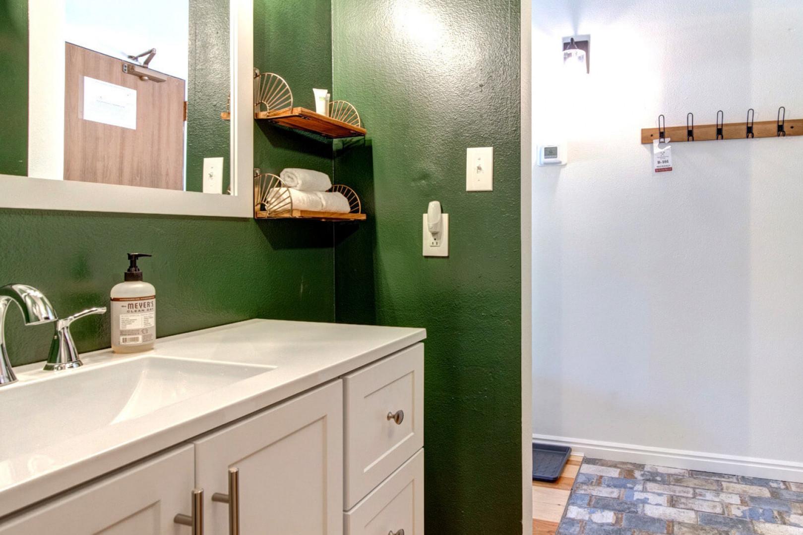 Sleek sink and mirror in a spacious, full bathroom oasis.