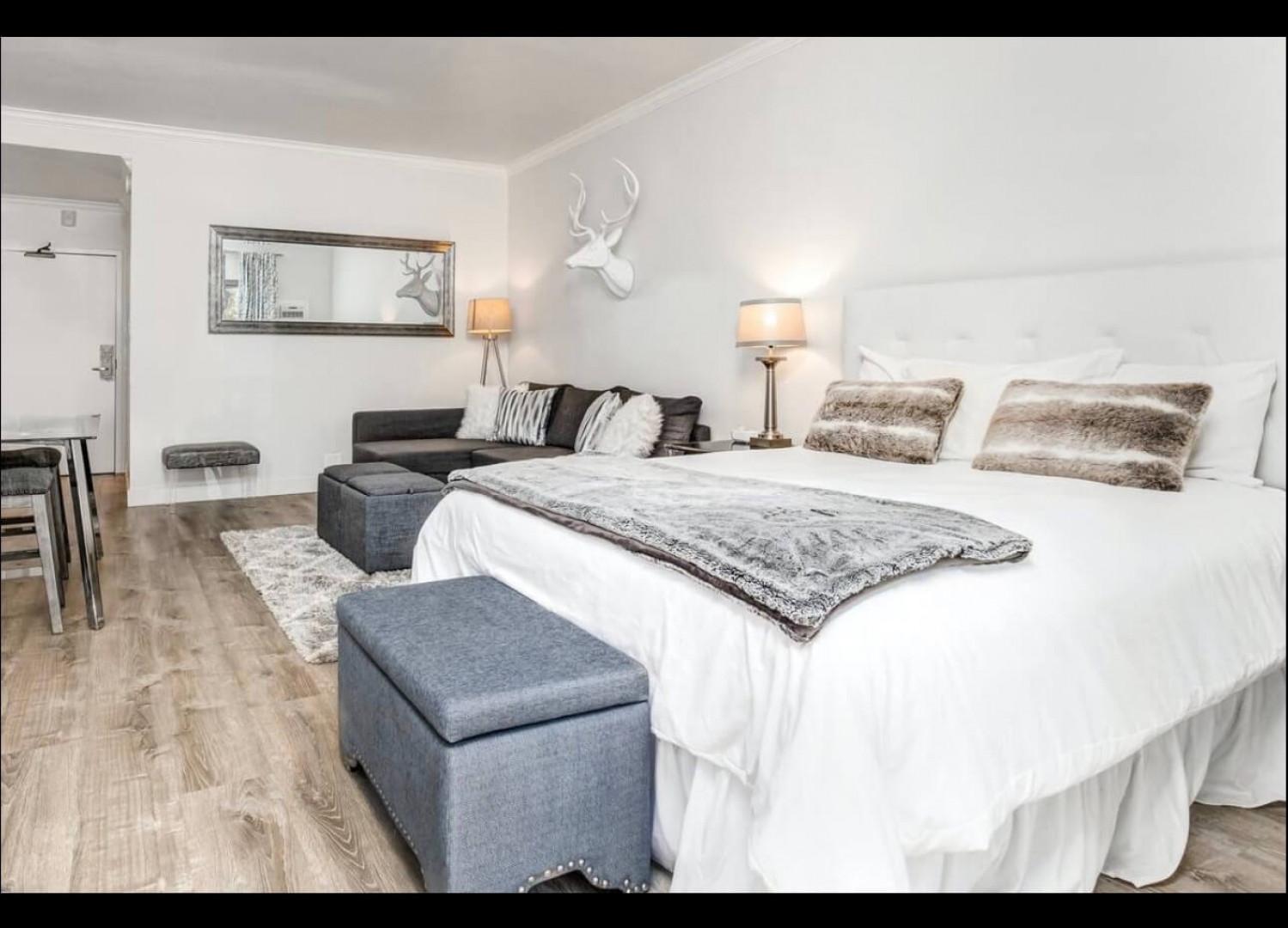 Sink into luxurious comfort in your elegantly appointed suite, where cozy seating and plush bedding create the perfect retreat for relaxation.