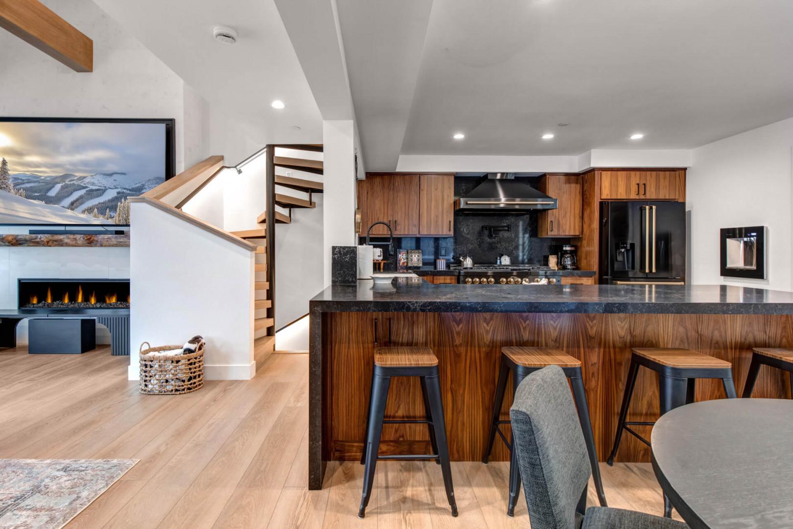 Upper Main 301: You'll love cooking and gathering in this stunning open kitchen with rich wood cabinetry, sleek black countertops, and bar seating.