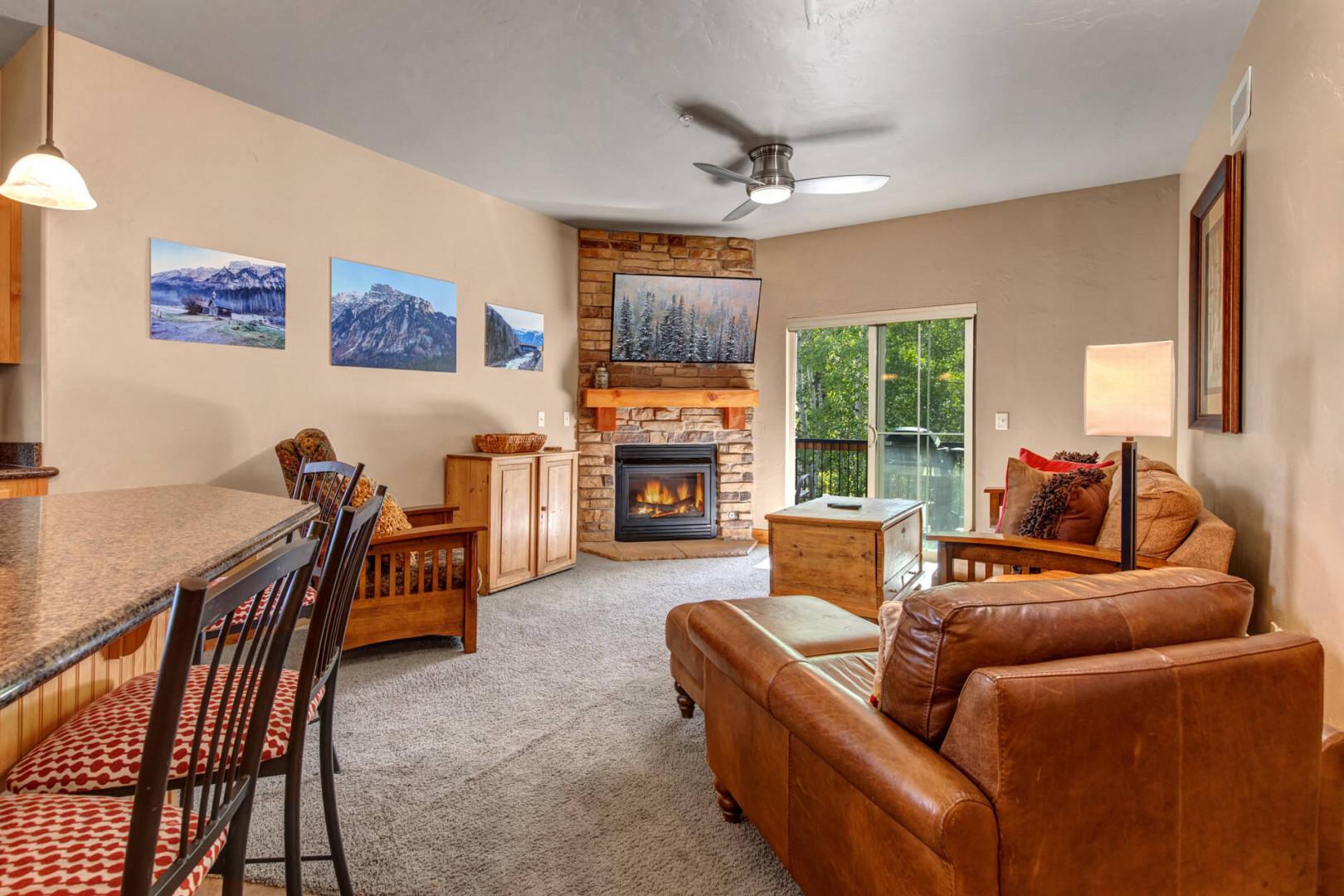 Unwind in your cozy living space with a stone fireplace, plush leather seating, and mountain views through the windows. Perfect for evenings in after exploring the area.