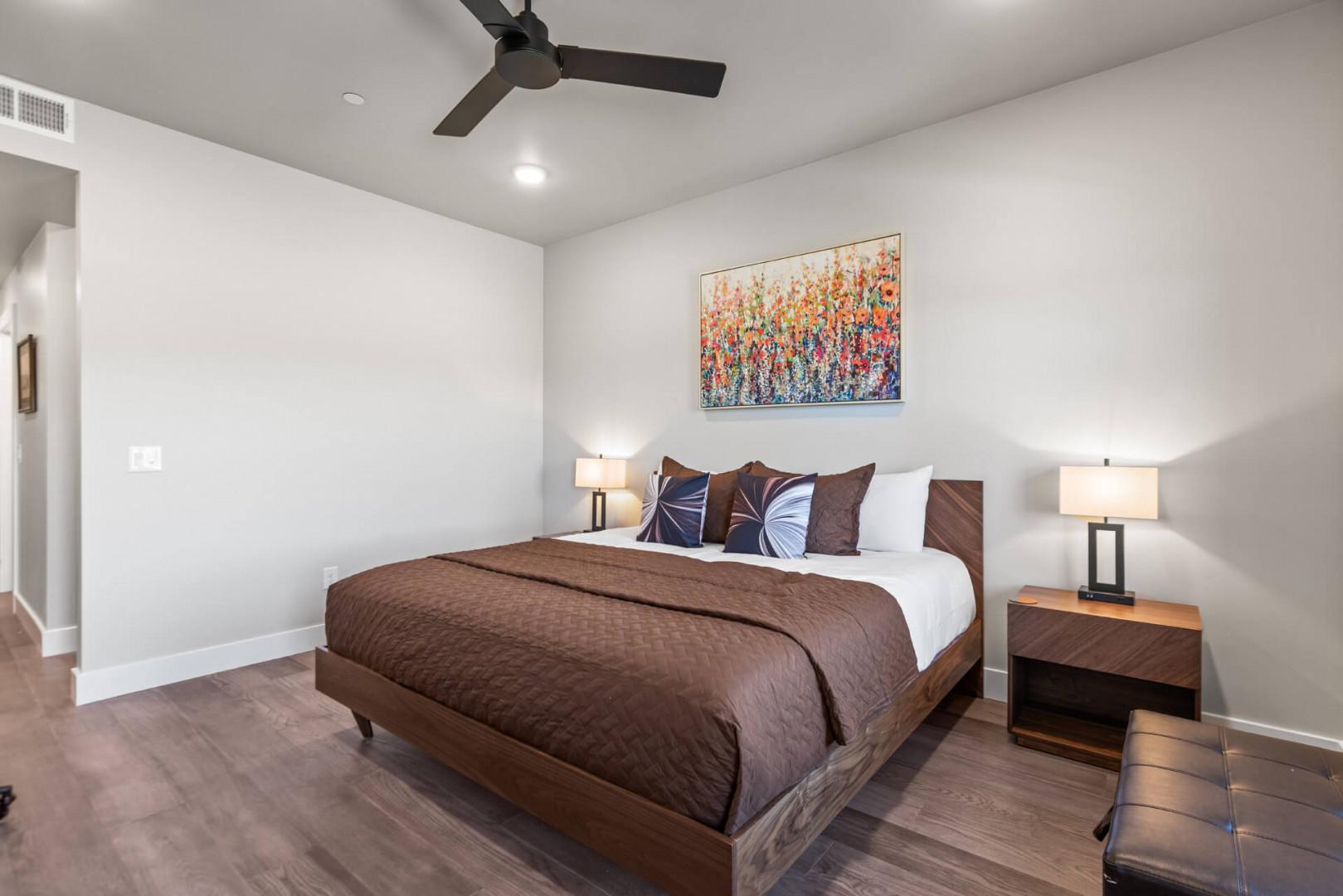 Step into your serene retreat, where a plush bed awaits beneath a gently spinning ceiling fan and warm bedside lighting invites you to unwind.