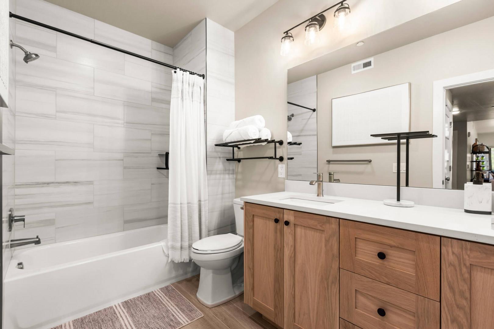Freshen up in your sleek, modern bathroom featuring a relaxing soaking tub, spacious vanity, and bright, clean design—your perfect retreat after a day of adventure.