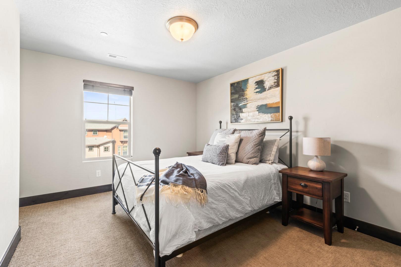 Slip into comfort in your peaceful bedroom retreat, featuring a cozy metal-framed bed and warm wood furnishings that create the perfect sanctuary.