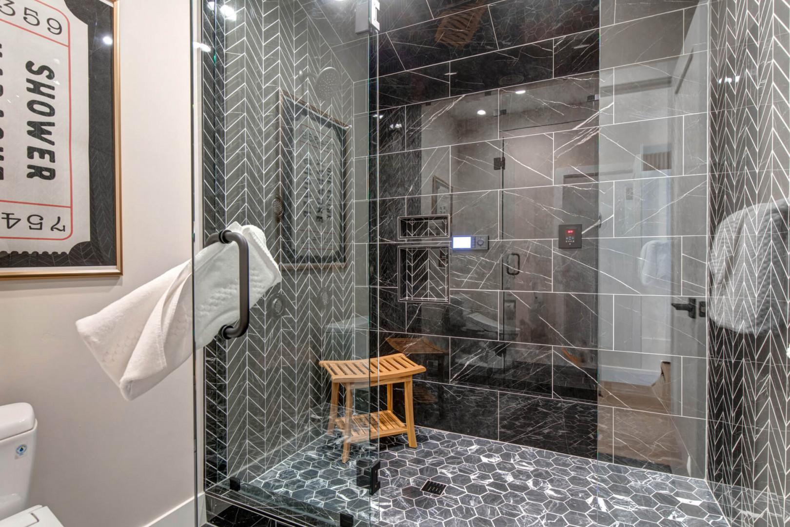 Upper Main 301: Slip into your spa-like shower sanctuary, where sleek glass walls and striking geometric tiles create the perfect luxury retreat.