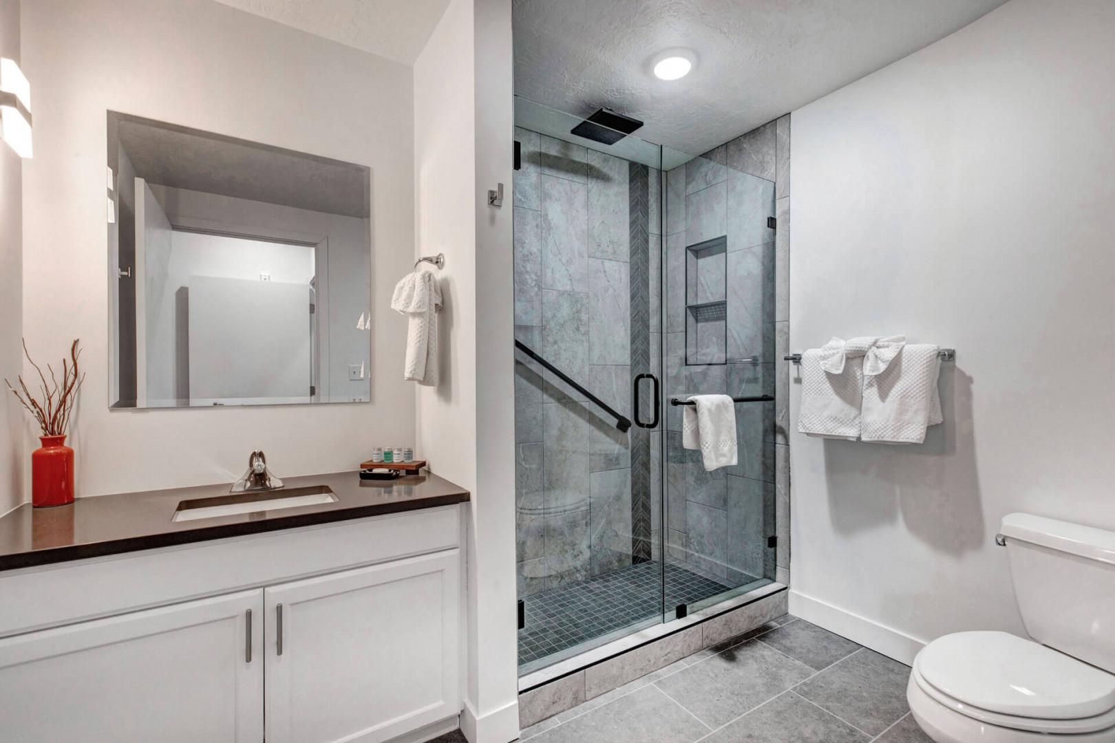 Indulge in your private spa-like bathroom featuring a luxurious glass-enclosed shower and elegant marble tiles for your ultimate relaxation.
